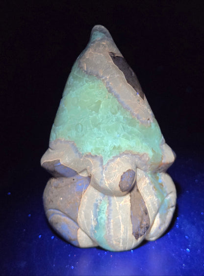 Carved Septarian gnome carving with yellow, brown and tan coloring showing UV reaction.