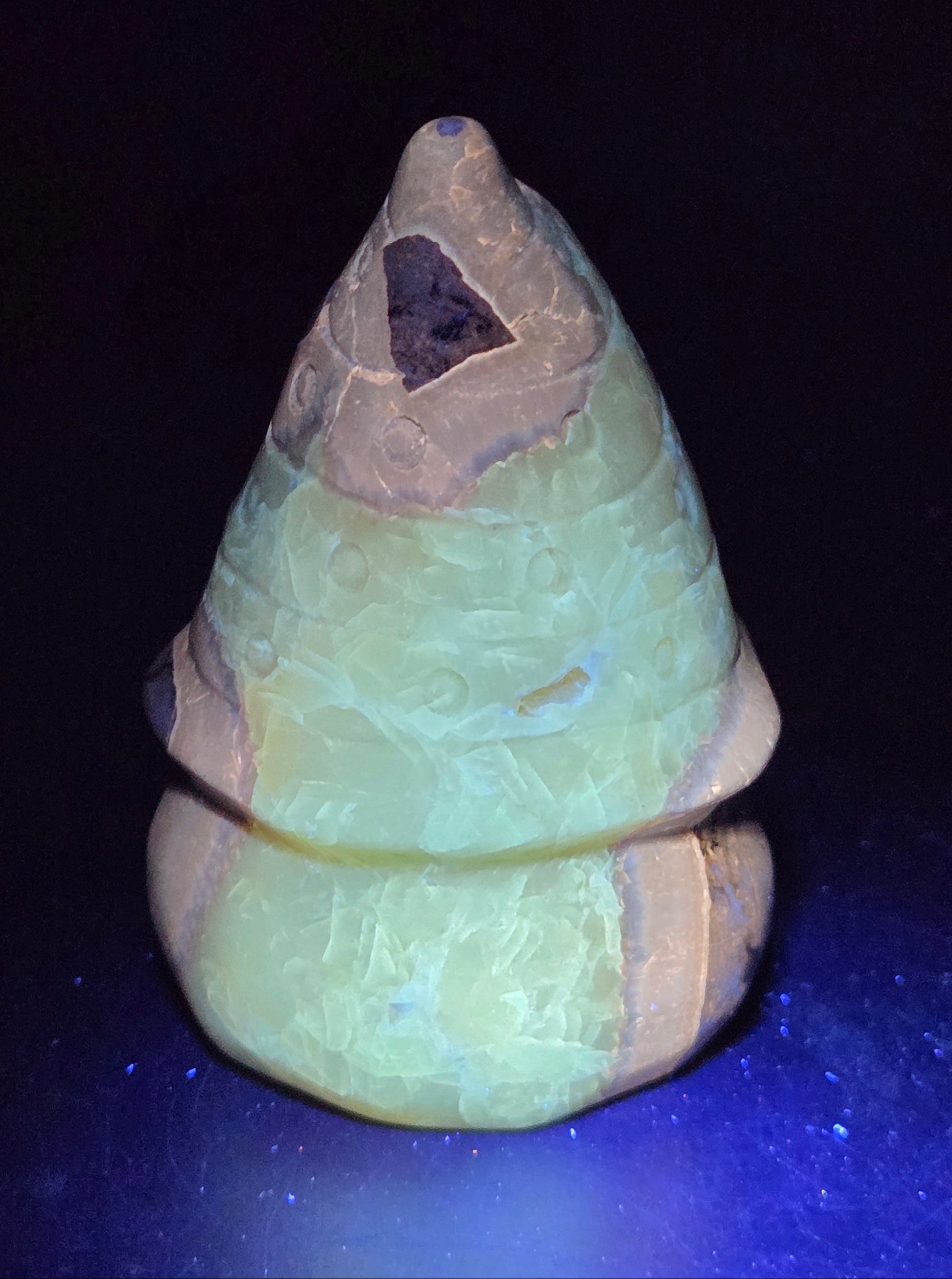 Carved Septarian gnome carving with yellow, brown and tan coloring showing UV reaction.