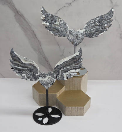 Decorative Zebra Calcite heart with wings, on a stand. Black and white banding and marble like patterns