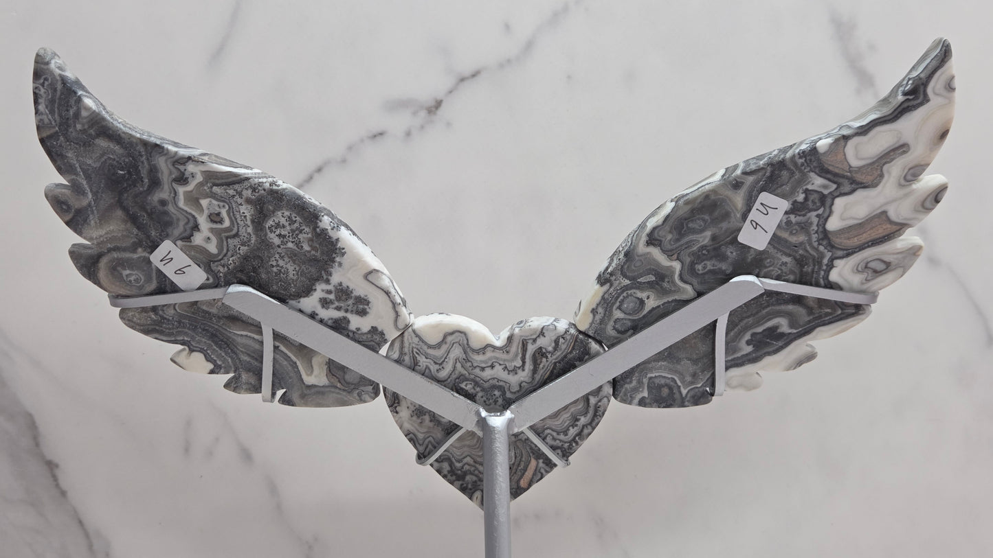 Decorative Zebra Calcite heart with wings, on a stand. Black and white banding and marble like patterns