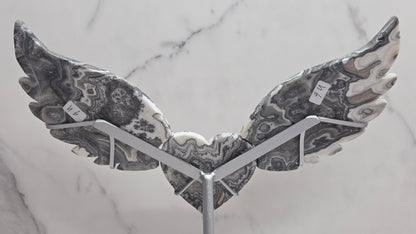 Decorative Zebra Calcite heart with wings, on a stand. Black and white banding and marble like patterns