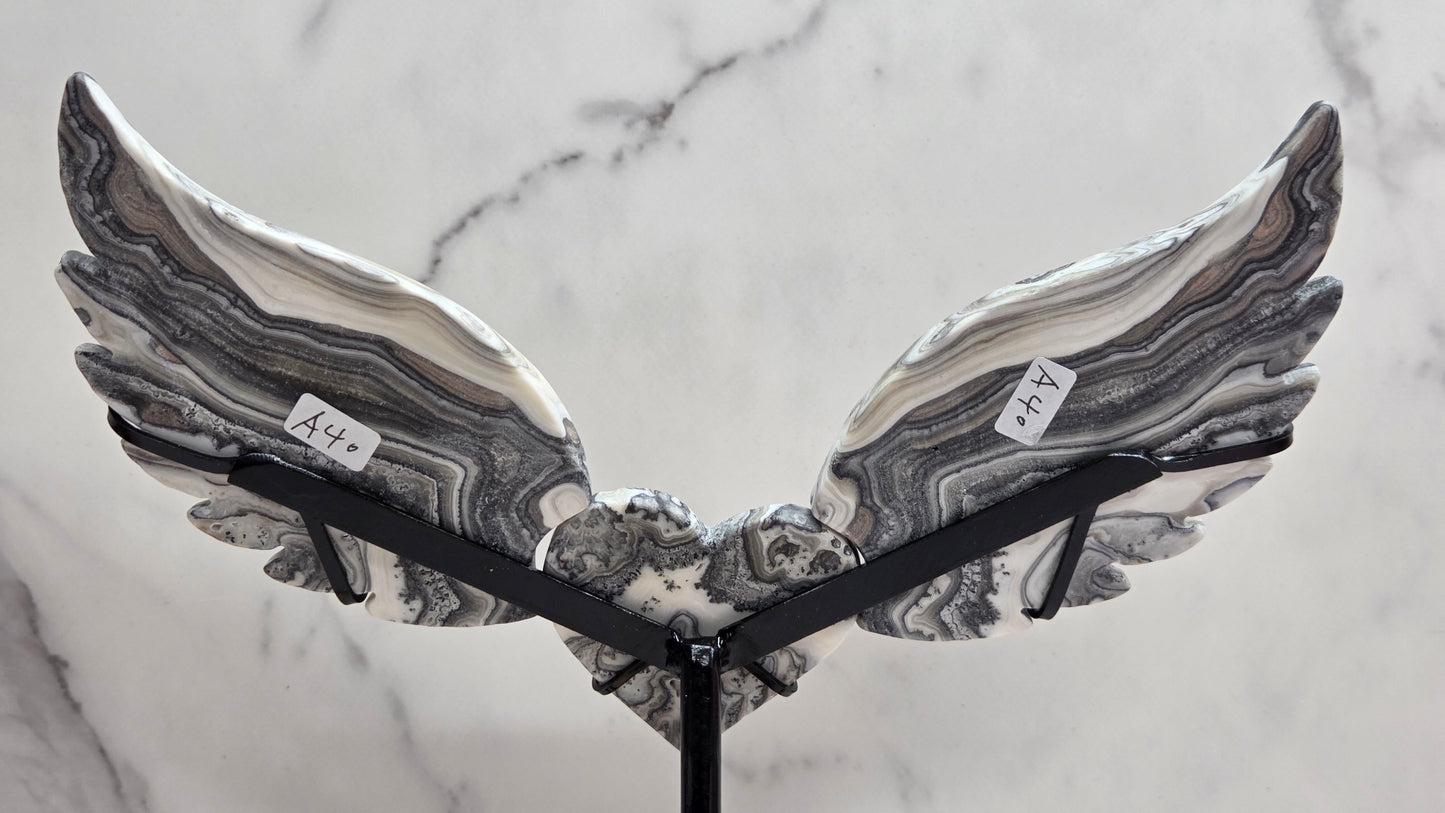 Decorative Zebra Calcite heart with wings, on a stand. Black and white banding and marble like patterns