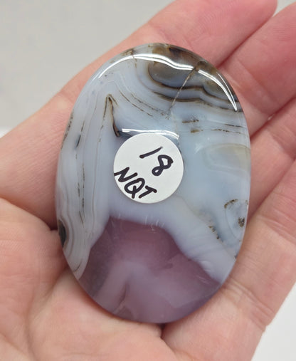 Hand holding a polished Jelly Agate palm with a marbled pattern