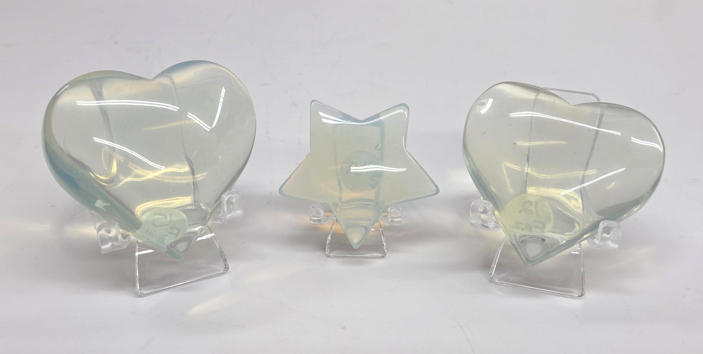 Three translucent Opalite hearts and star objects on a white background