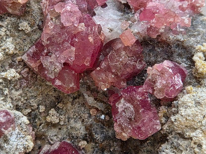 Close-up of pink crystal formations on a textured surface