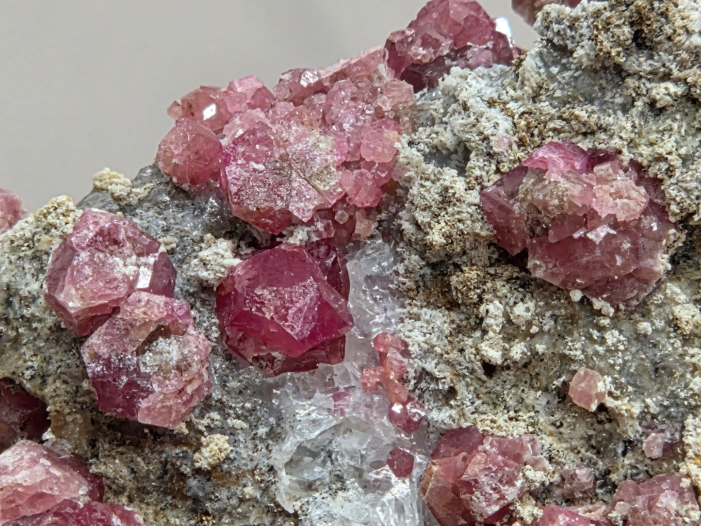 Close-up of pink crystal formations on a grayish background
