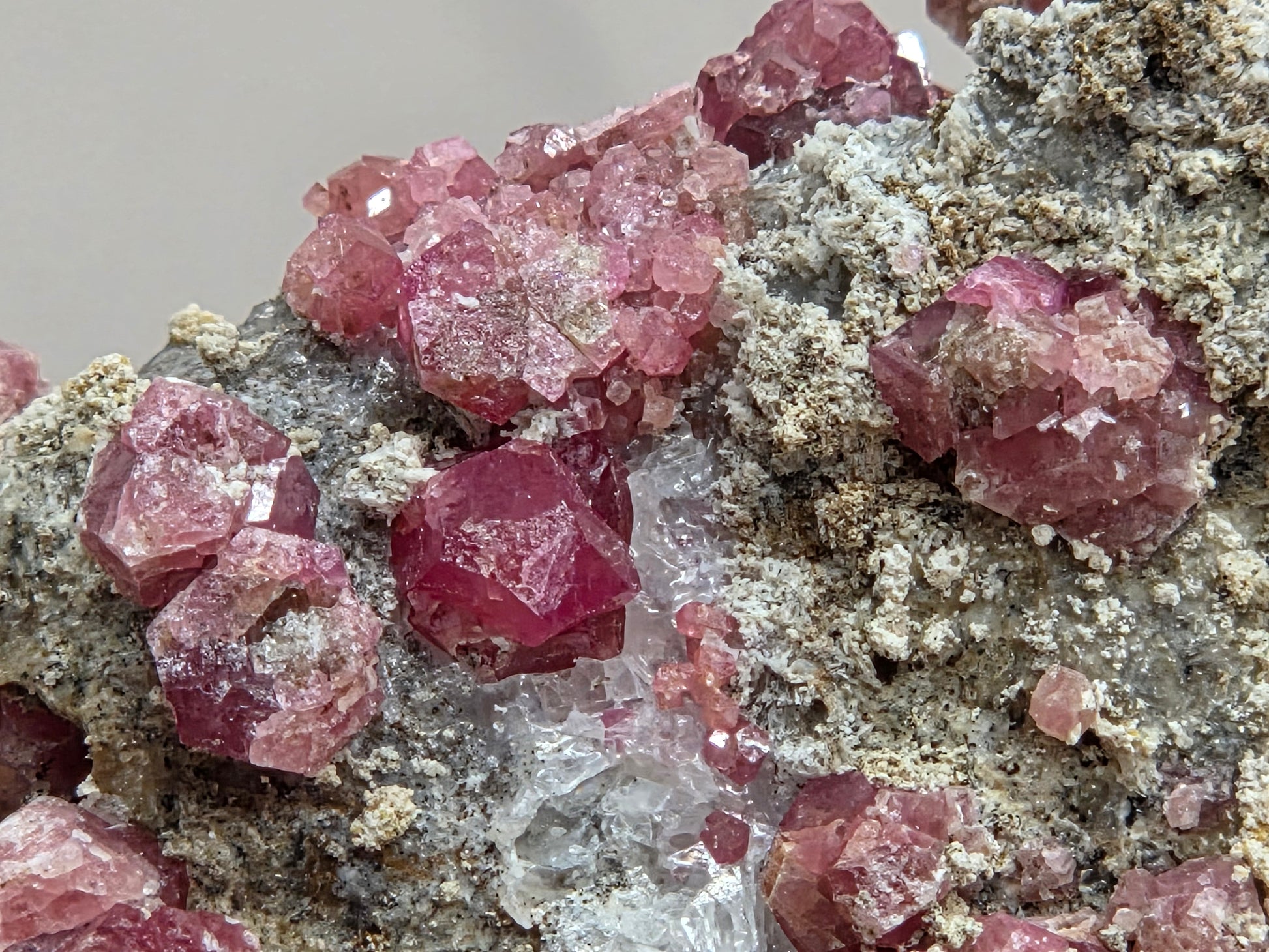 Close-up of pink crystal formations on a grayish background