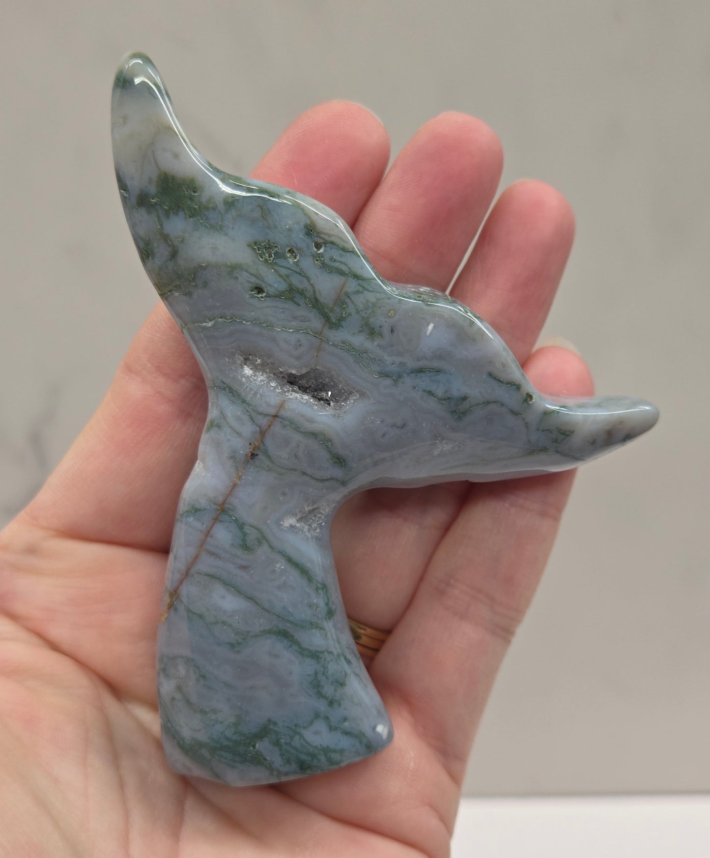 stone carvings of stylized whale tales, green, blues and greys and drusy crystal caves