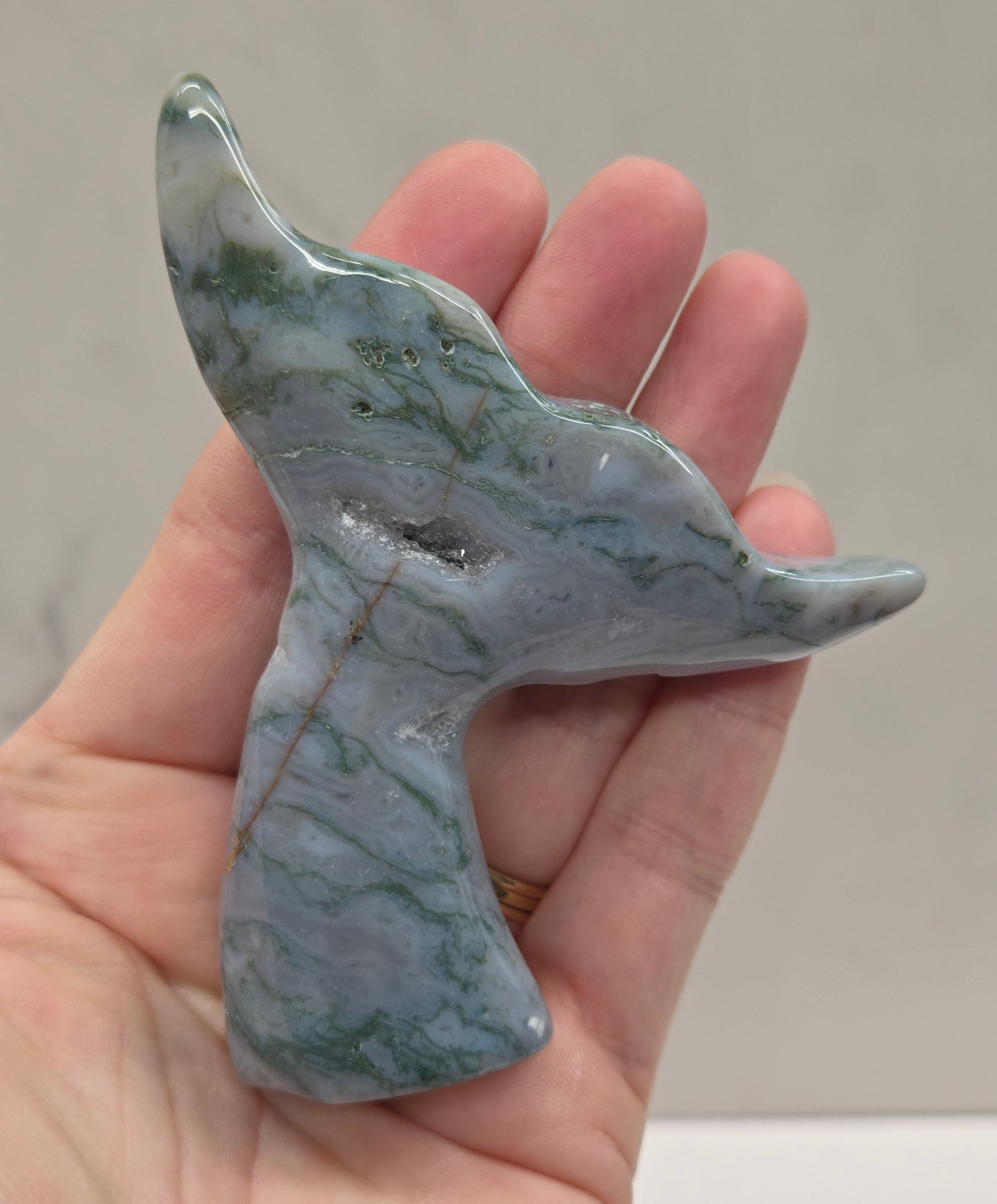 stone carvings of stylized whale tales, green, blues and greys and drusy crystal caves