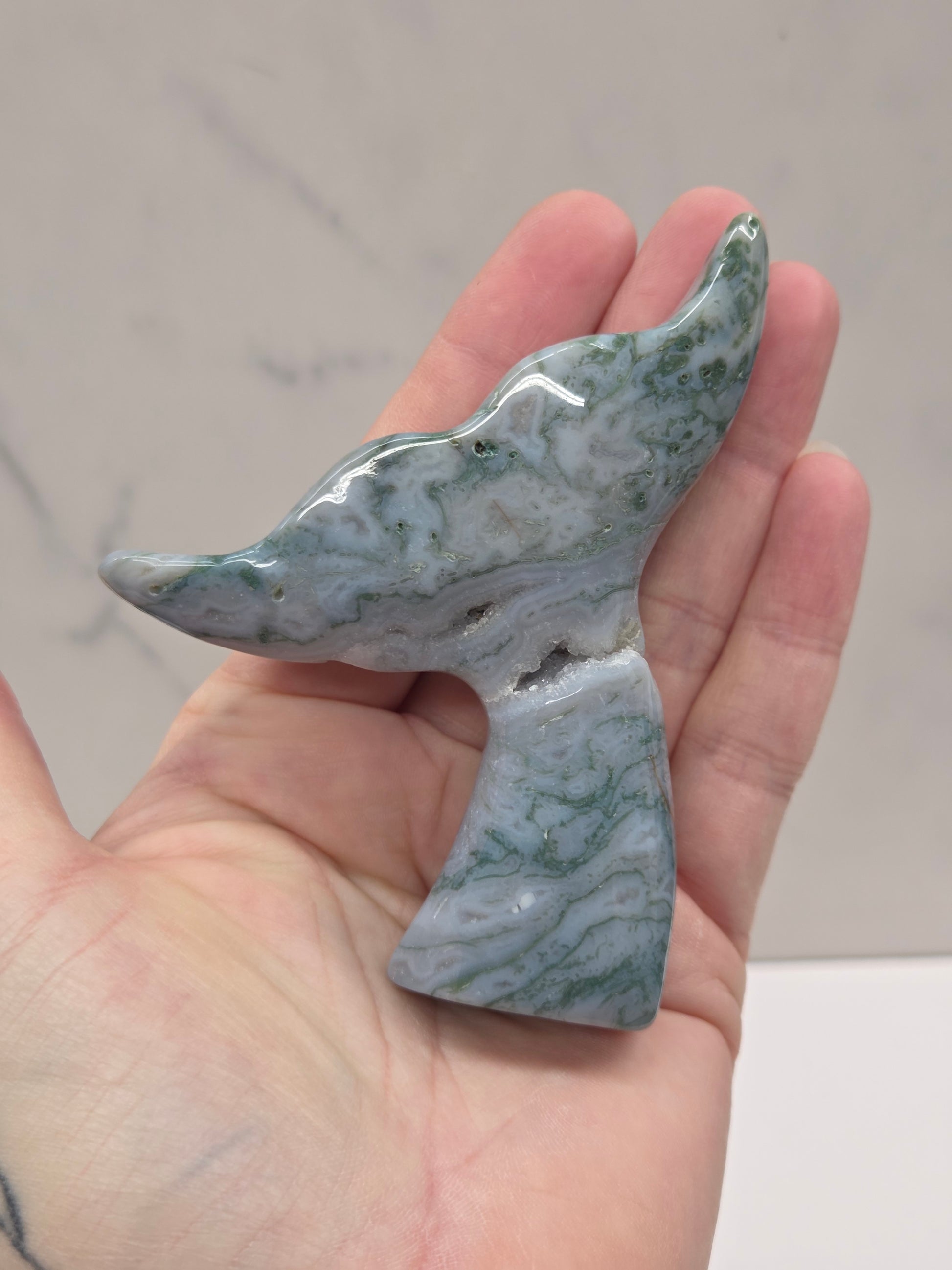 stone carvings of stylized whale tales, green, blues and greys and drusy crystal caves