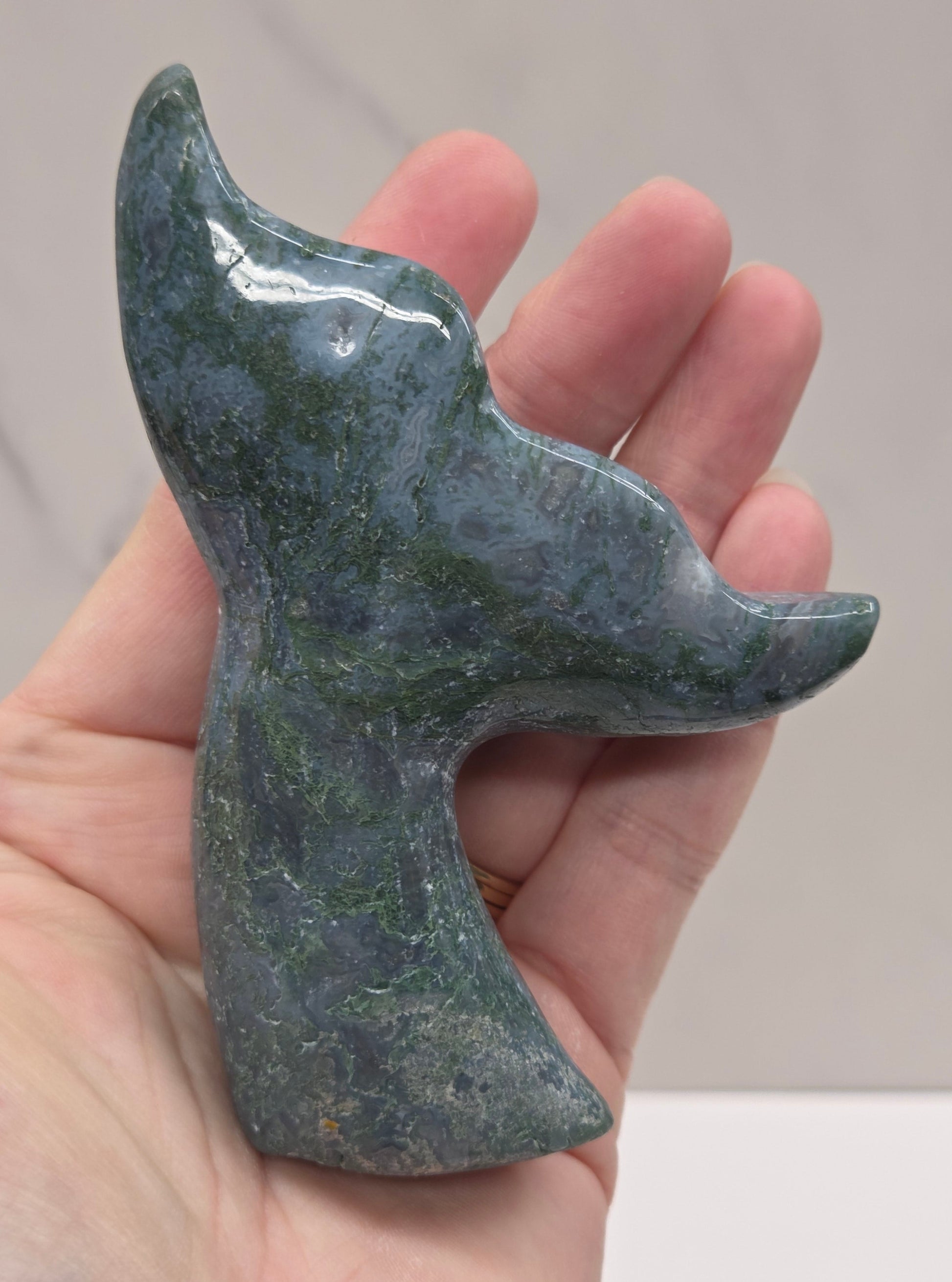 stone carvings of stylized whale tales, green, blues and greys and drusy crystal caves