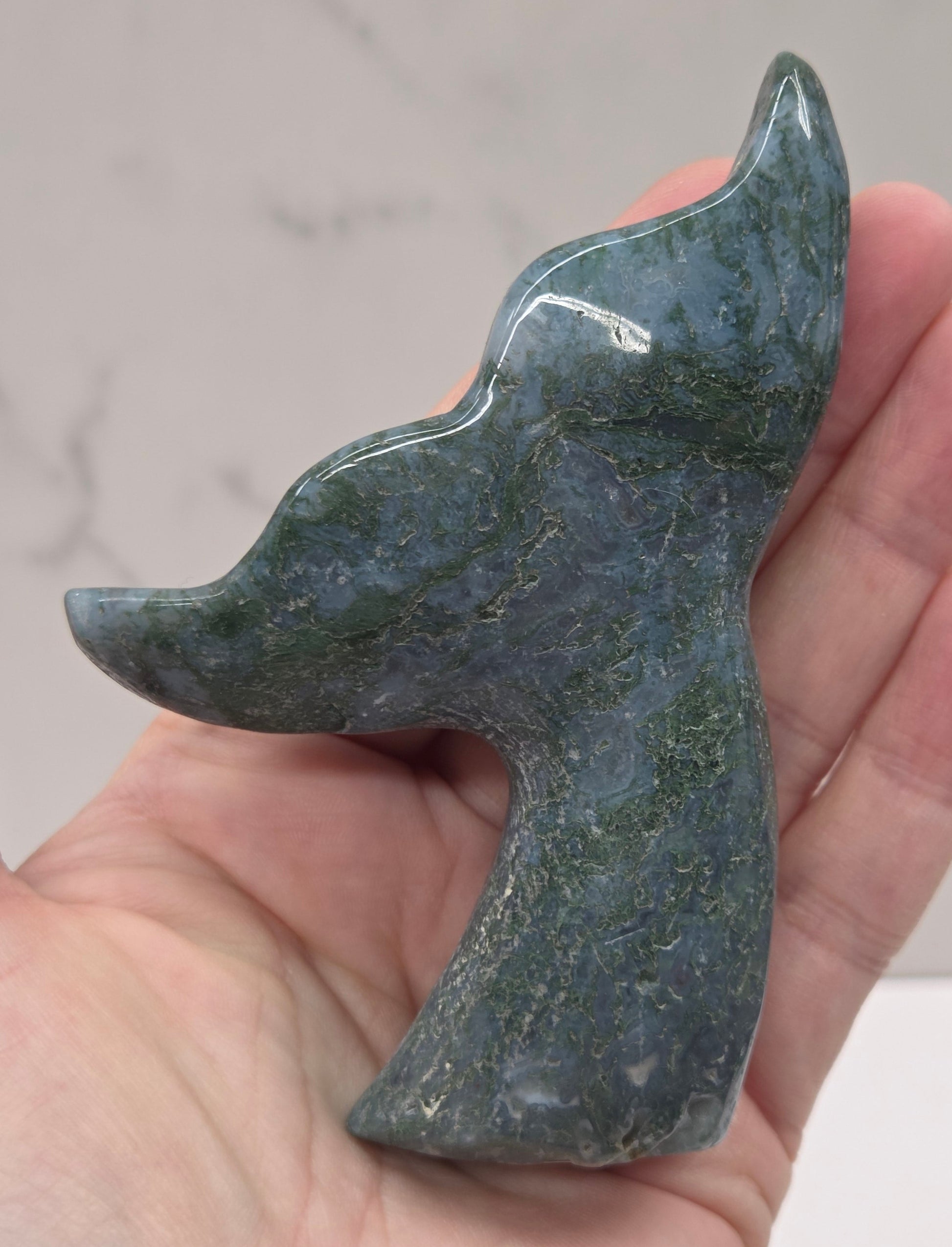 stone carvings of stylized whale tales, green, blues and greys and drusy crystal caves