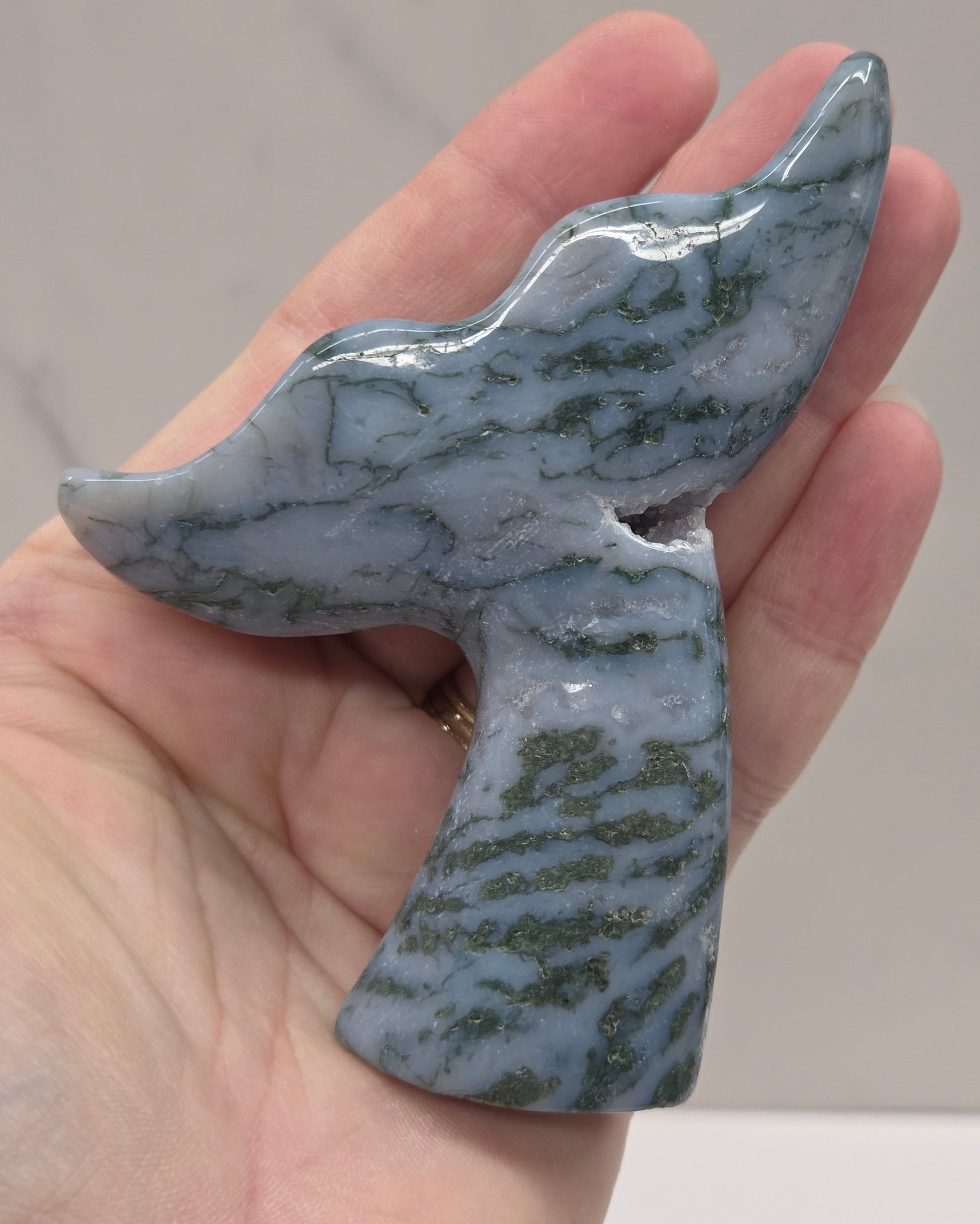 stone carvings of stylized whale tales, green, blues and greys and drusy crystal caves
