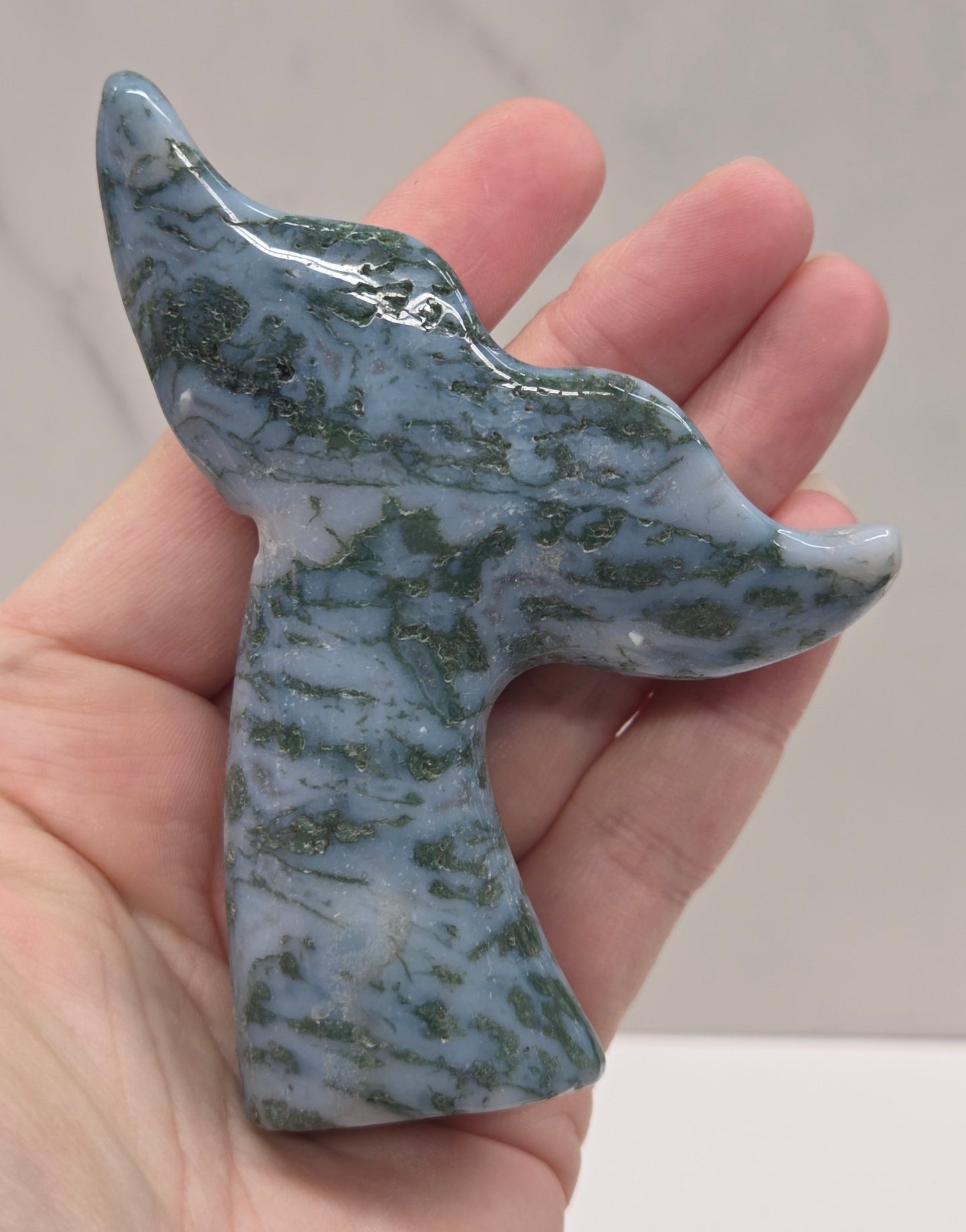 stone carvings of stylized whale tales, green, blues and greys and drusy crystal caves