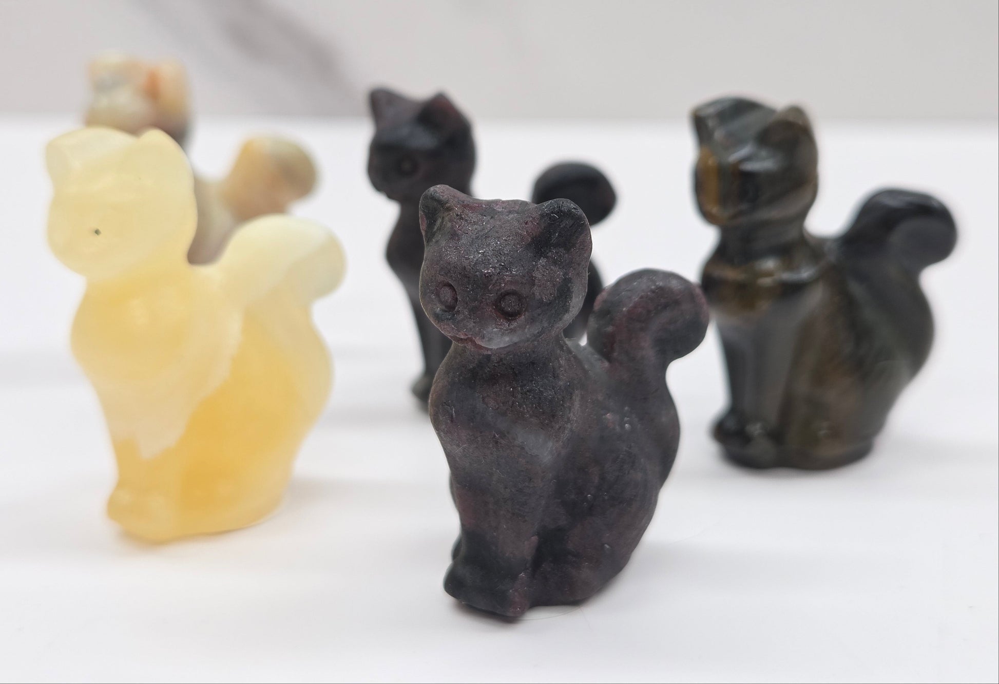 Set of black and beige cat-shaped carvings on a white surface