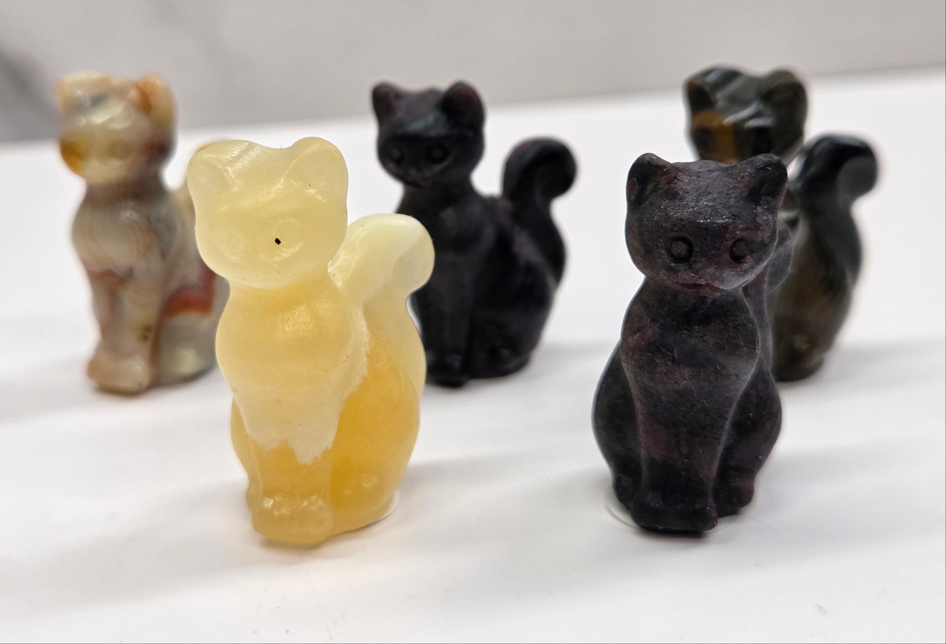 Set of black and beige cat-shaped carvings on a white surface