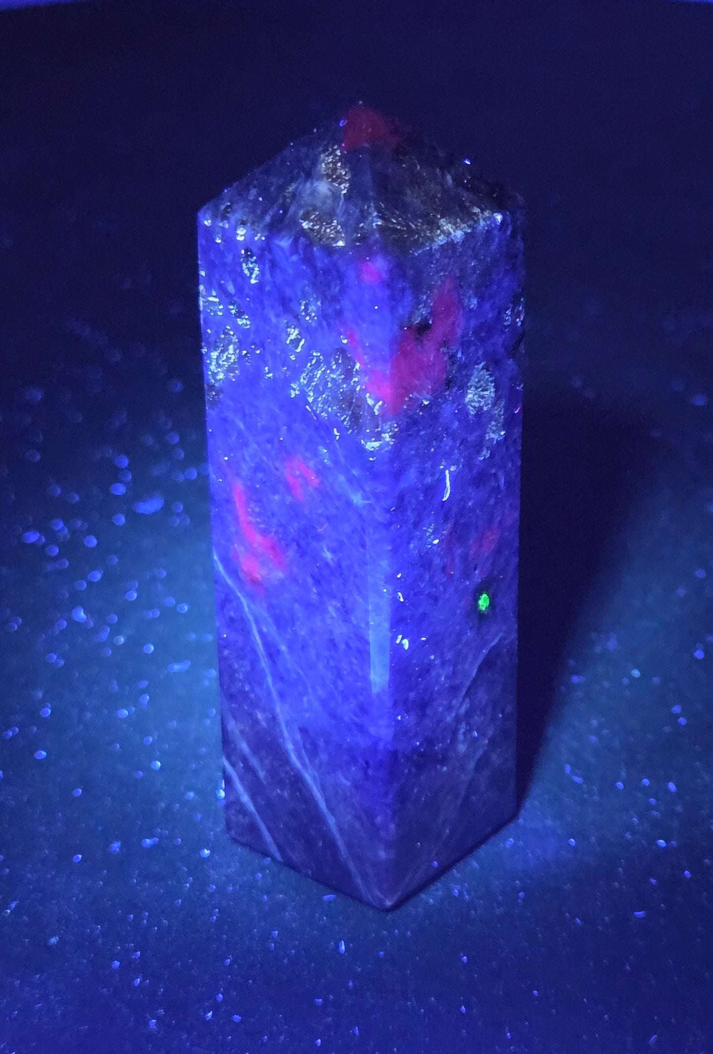 Purple Charoite crystal tower under UV light