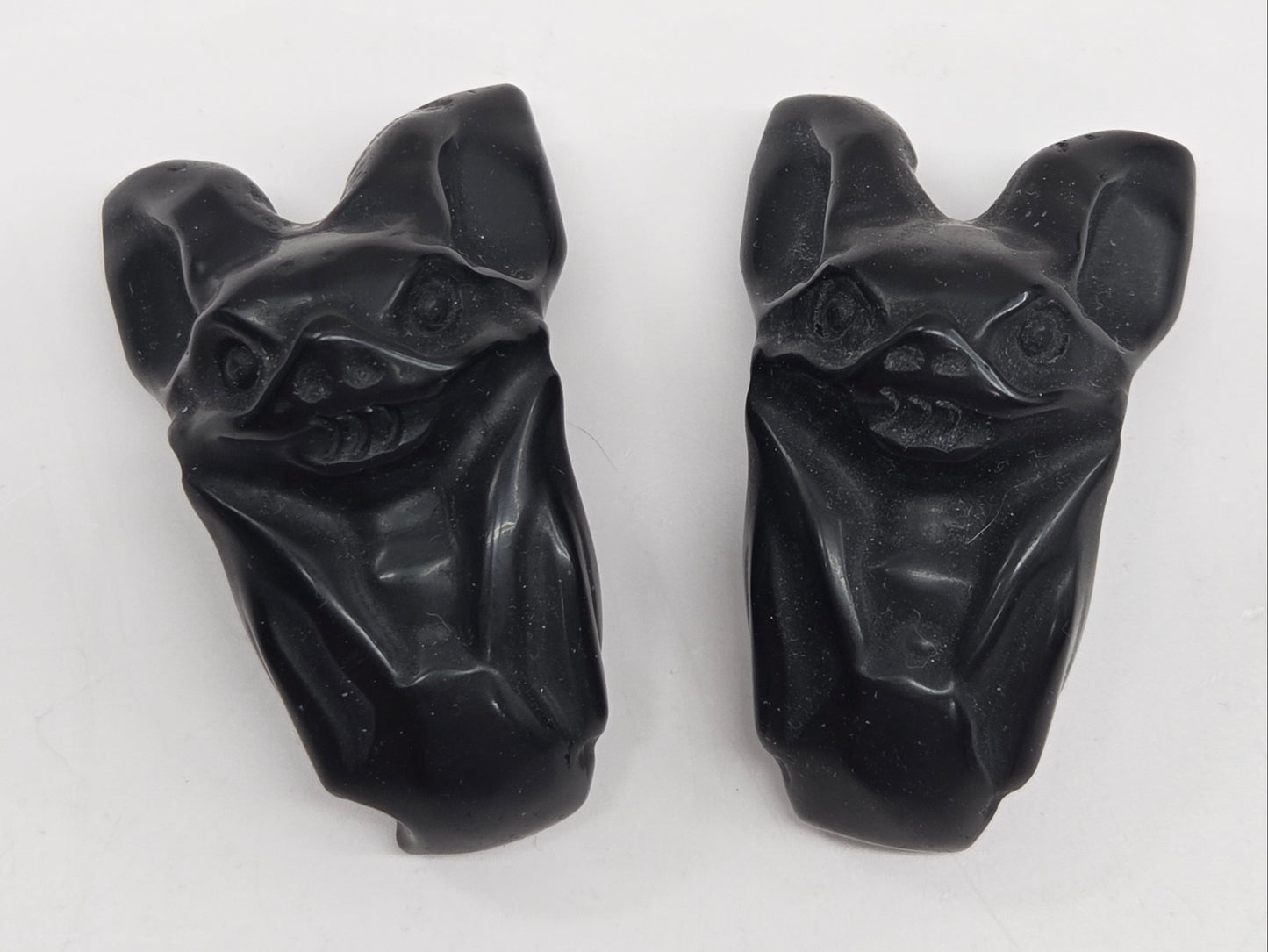 Two black Obsidian bat carvings