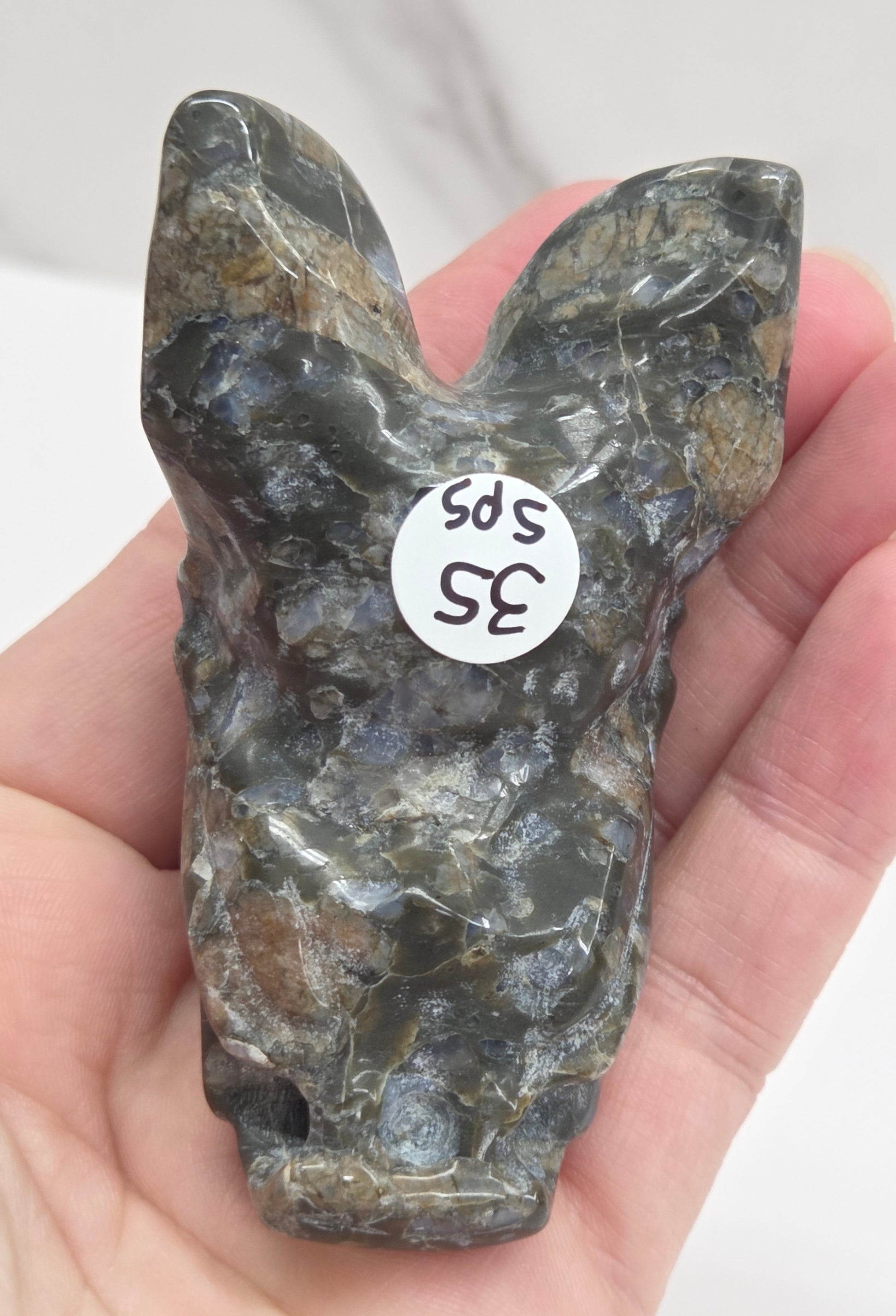 Back side of a Que Sera bat carving with black and blue coloring