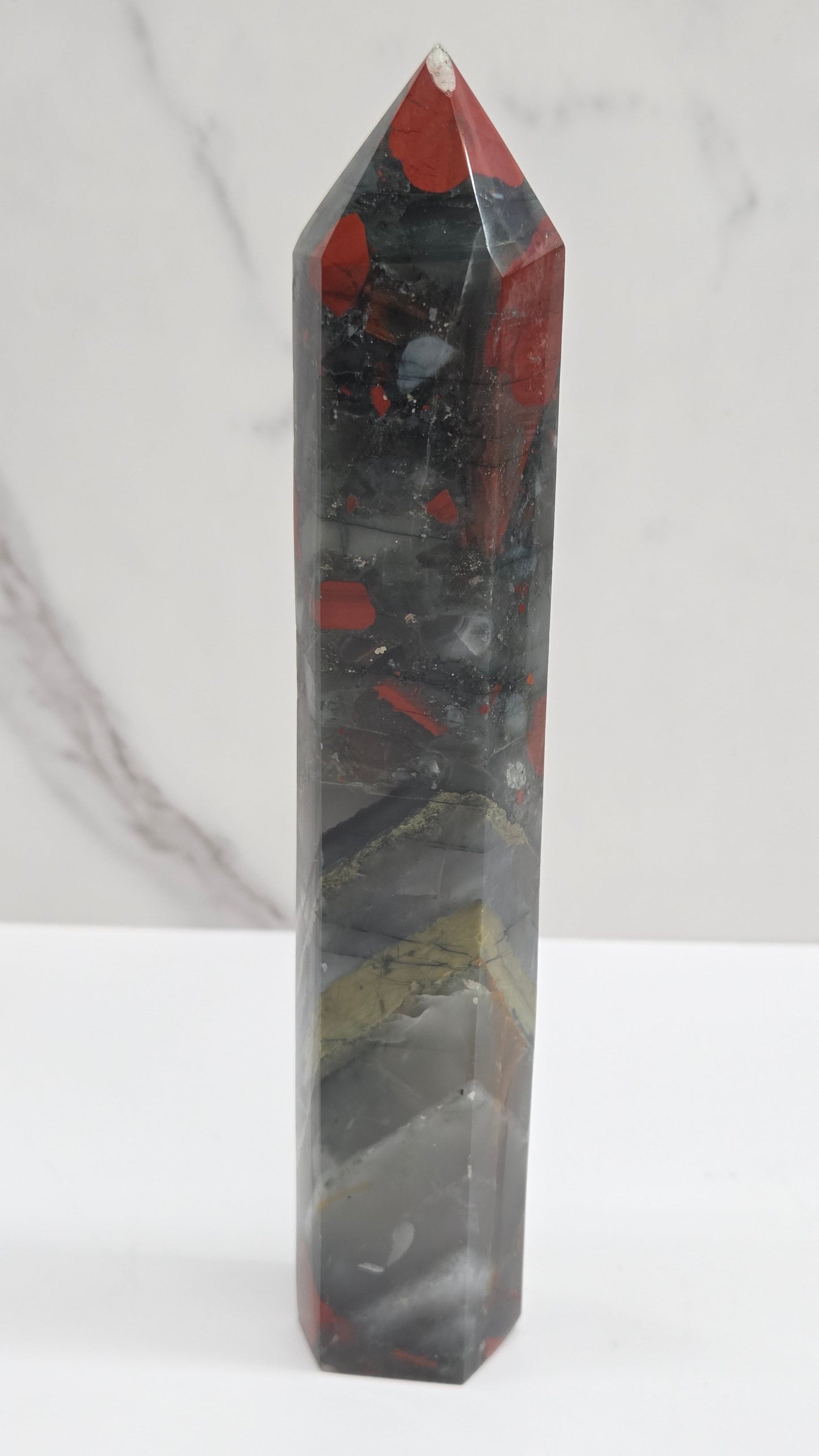 Crystal African Bloodstone tower with red and black patterns on a white surface