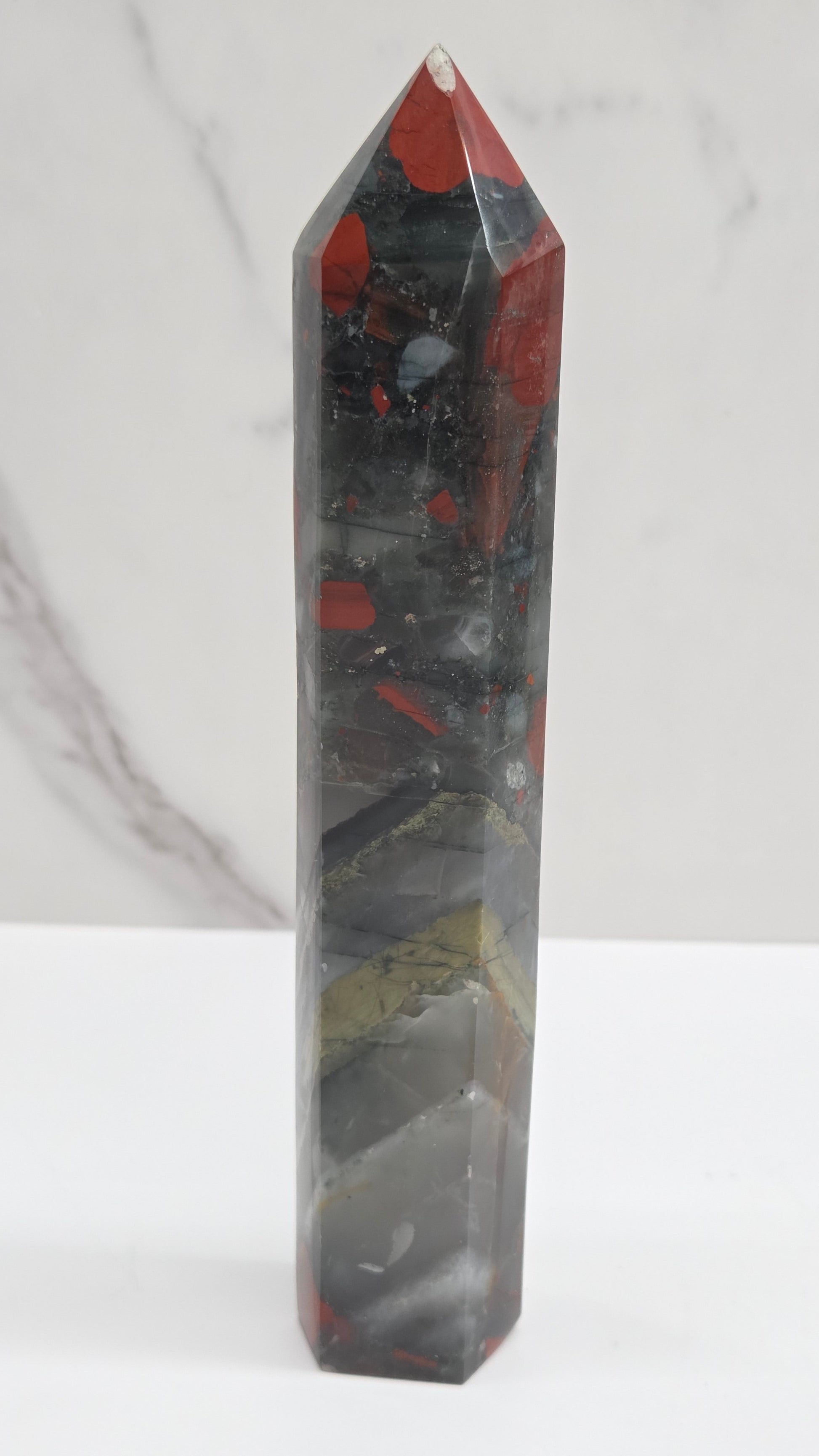 Crystal African Bloodstone tower with red and black patterns on a white surface