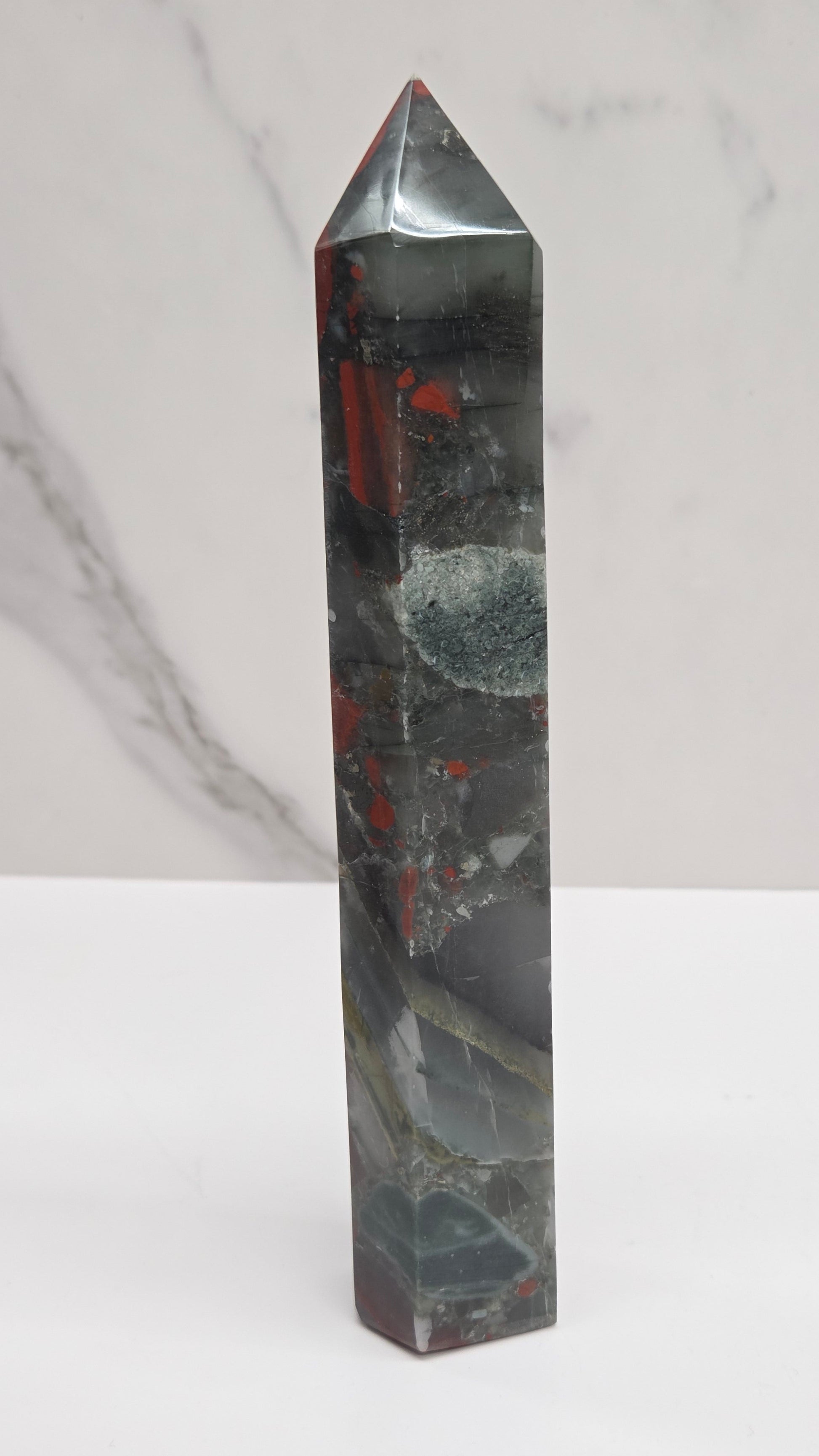 Crystal African Bloodstone tower with red and black patterns on a white surface