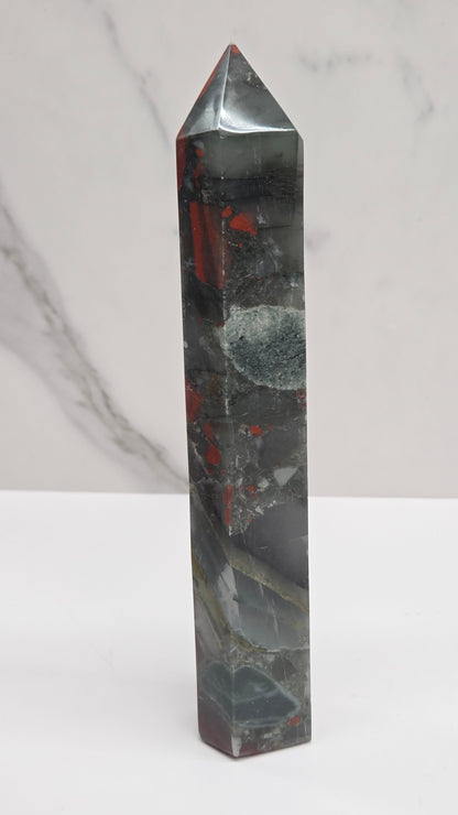 Crystal African Bloodstone tower with red and black patterns on a white surface