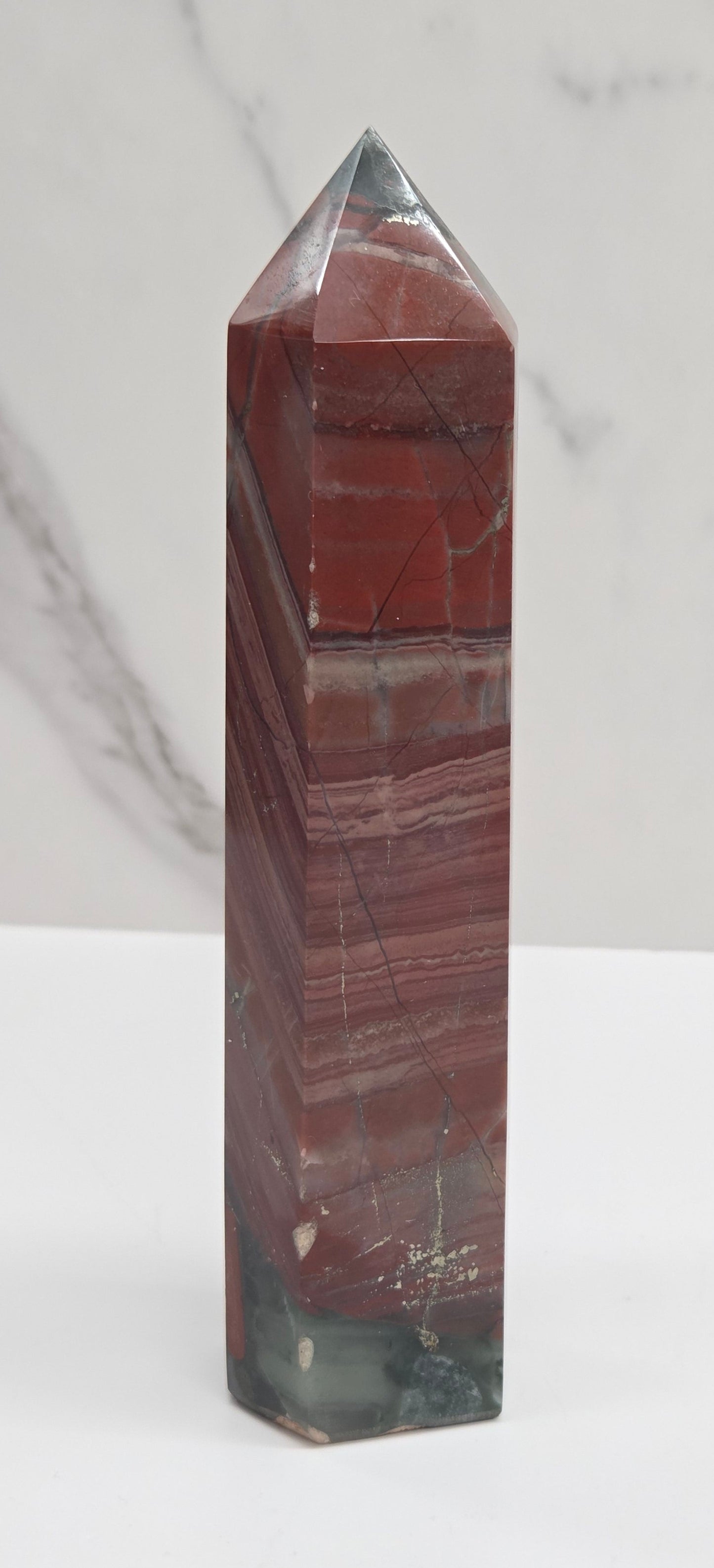 Crystal African Bloodstone tower with red and black patterns on a white surface