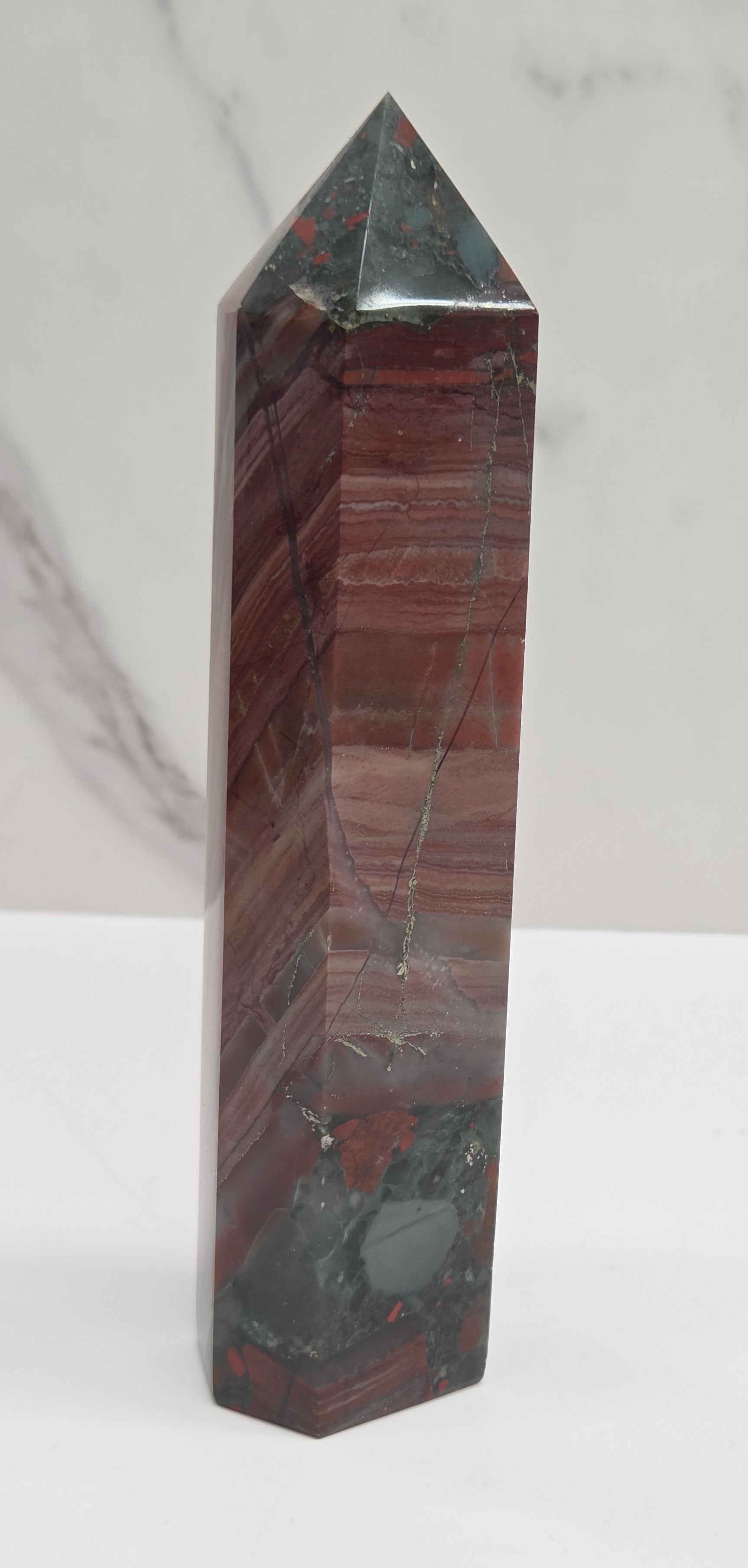 Crystal African Bloodstone tower with red and black patterns on a white surface