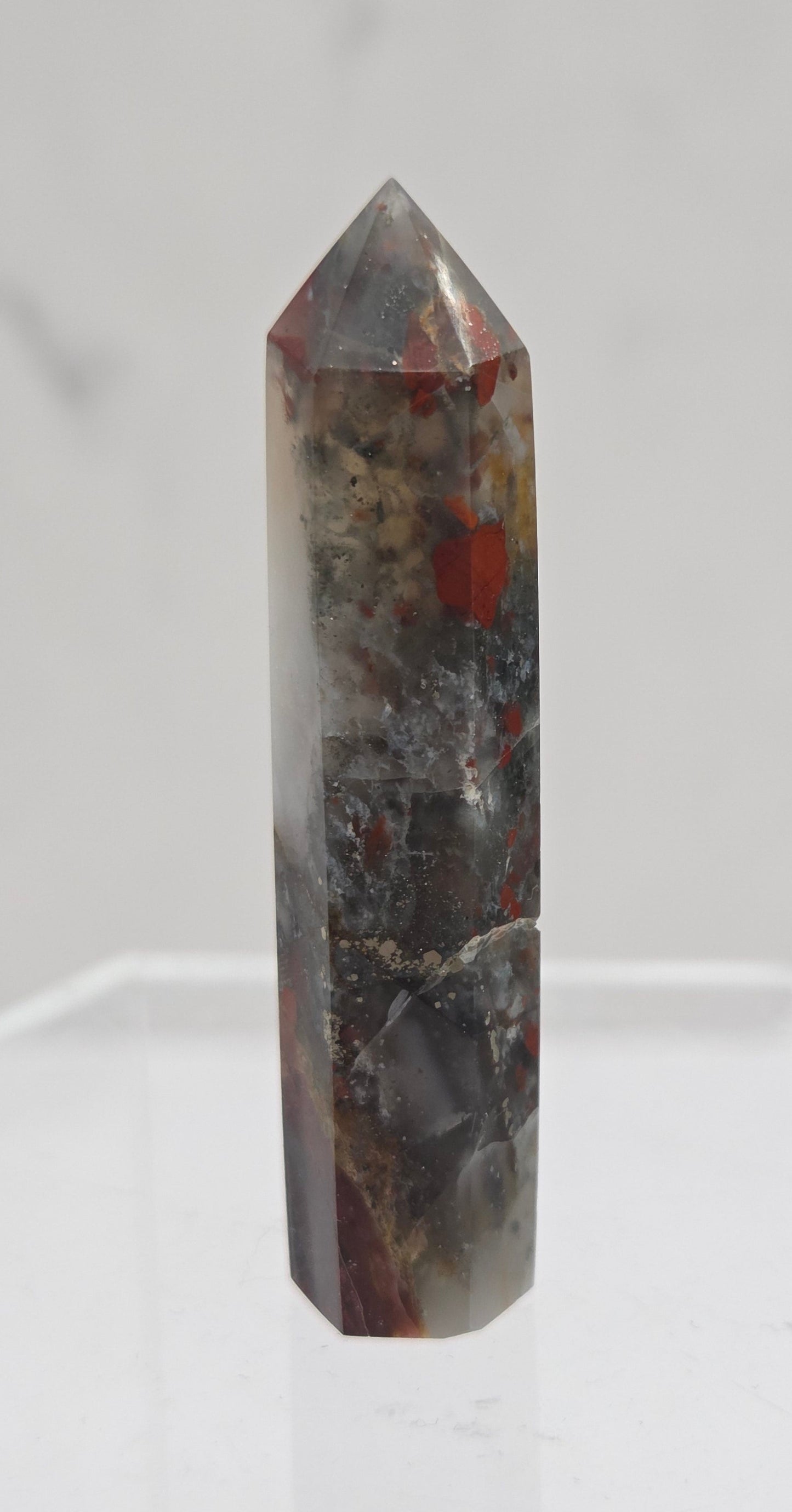 African Bloodstone crystal tower with red and black patterns on a white background