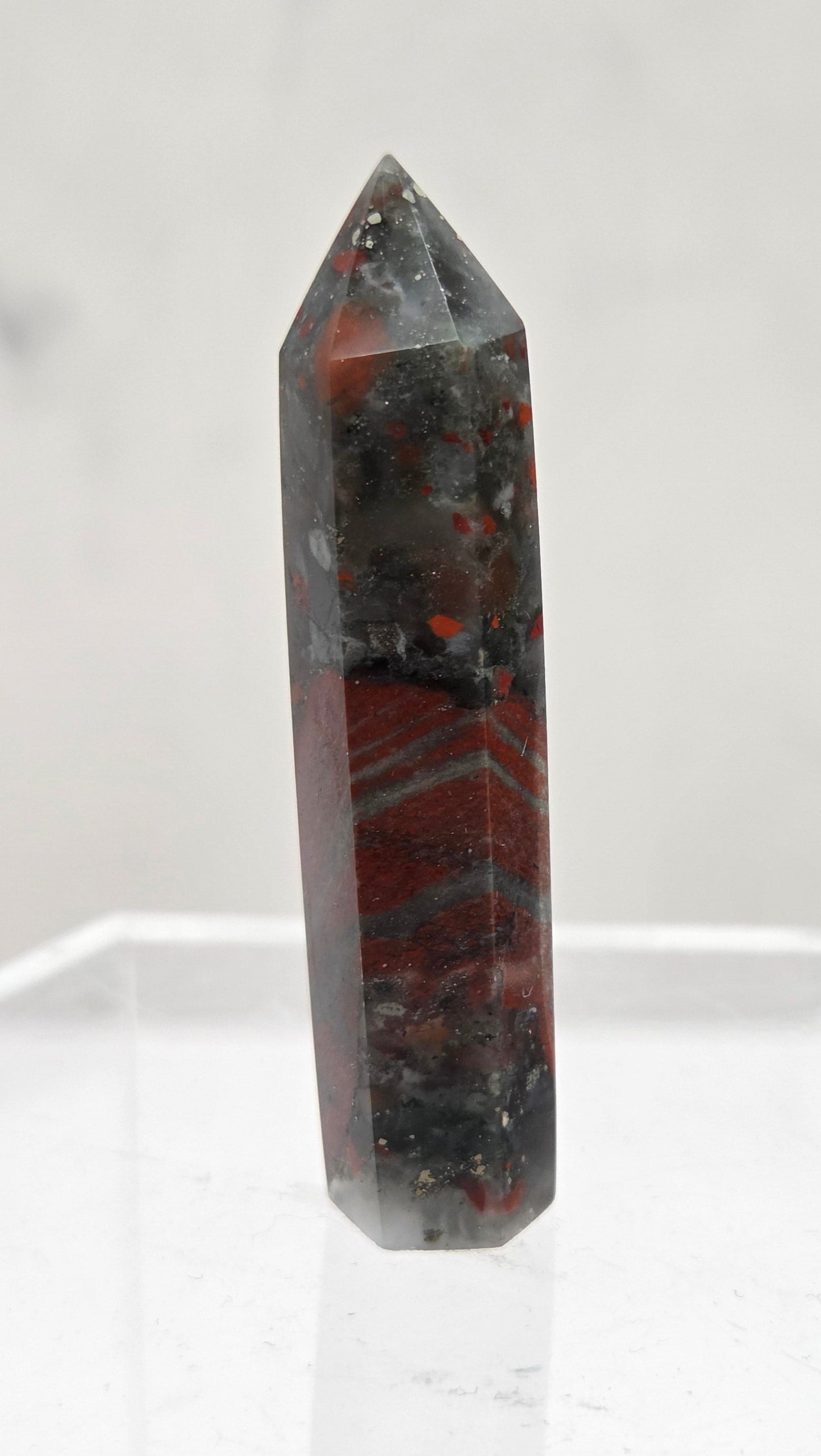 African Bloodstone crystal tower with red and black patterns on a white background