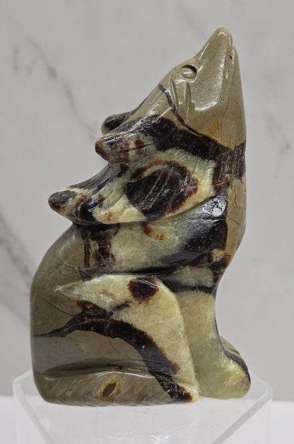 Septarian wolf carving with yellow, tan and brown coloring on a white background