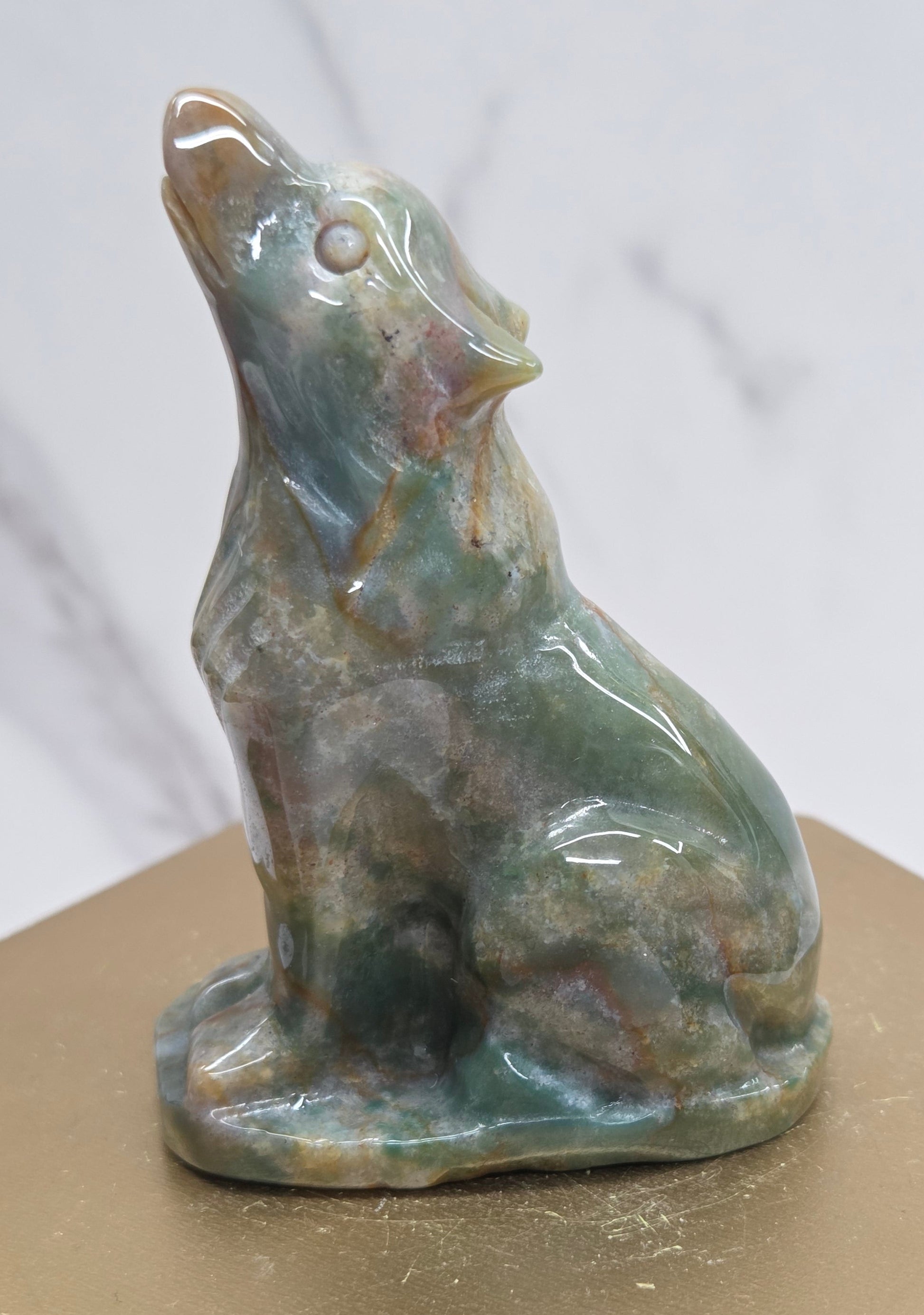 Ocean Jasper wolf carving on a neutral background