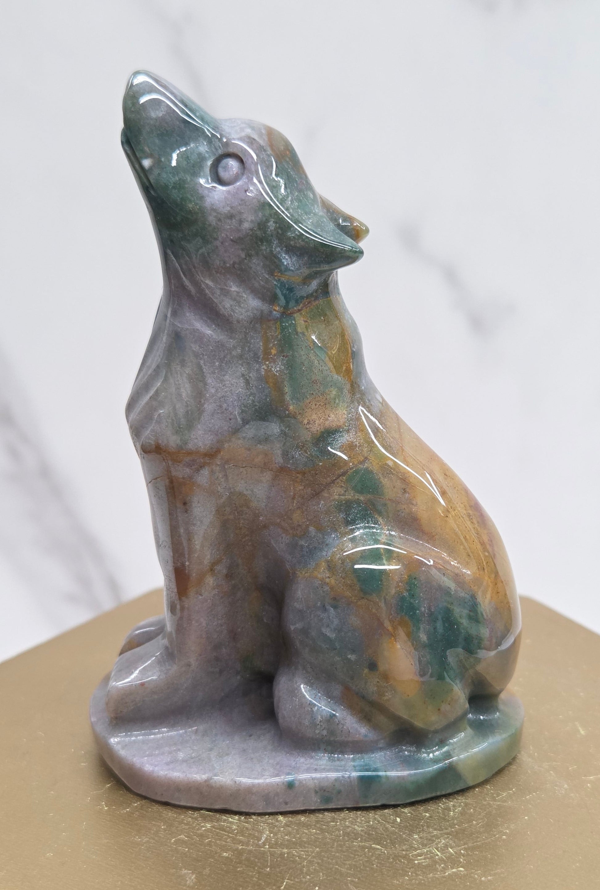 Ocean Jasper wolf carving on a neutral background