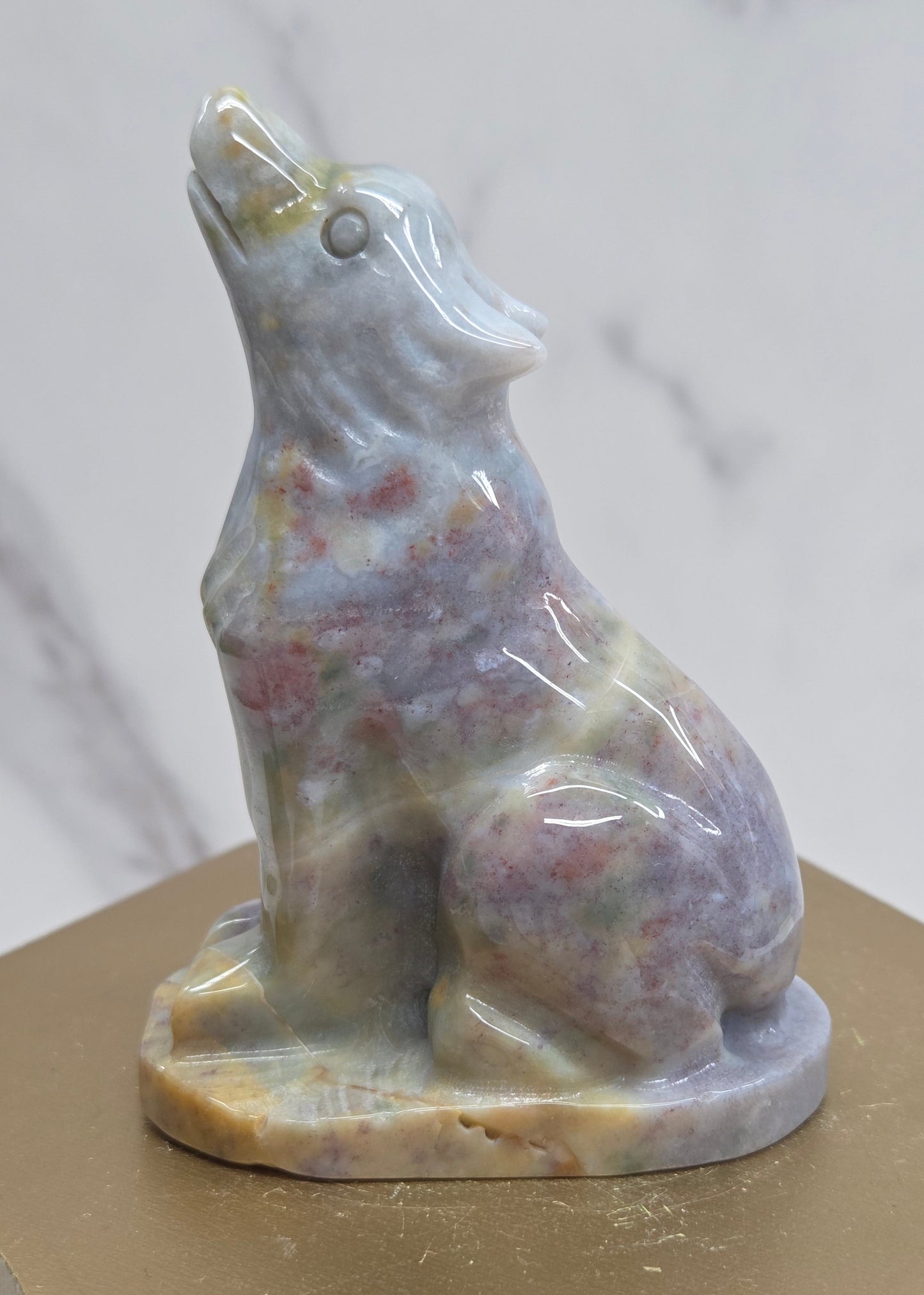 Ocean Jasper wolf carving on a neutral background