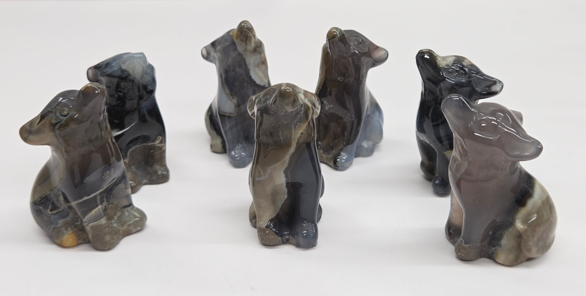 Set of Volcano Agate wolf figurines on a white background