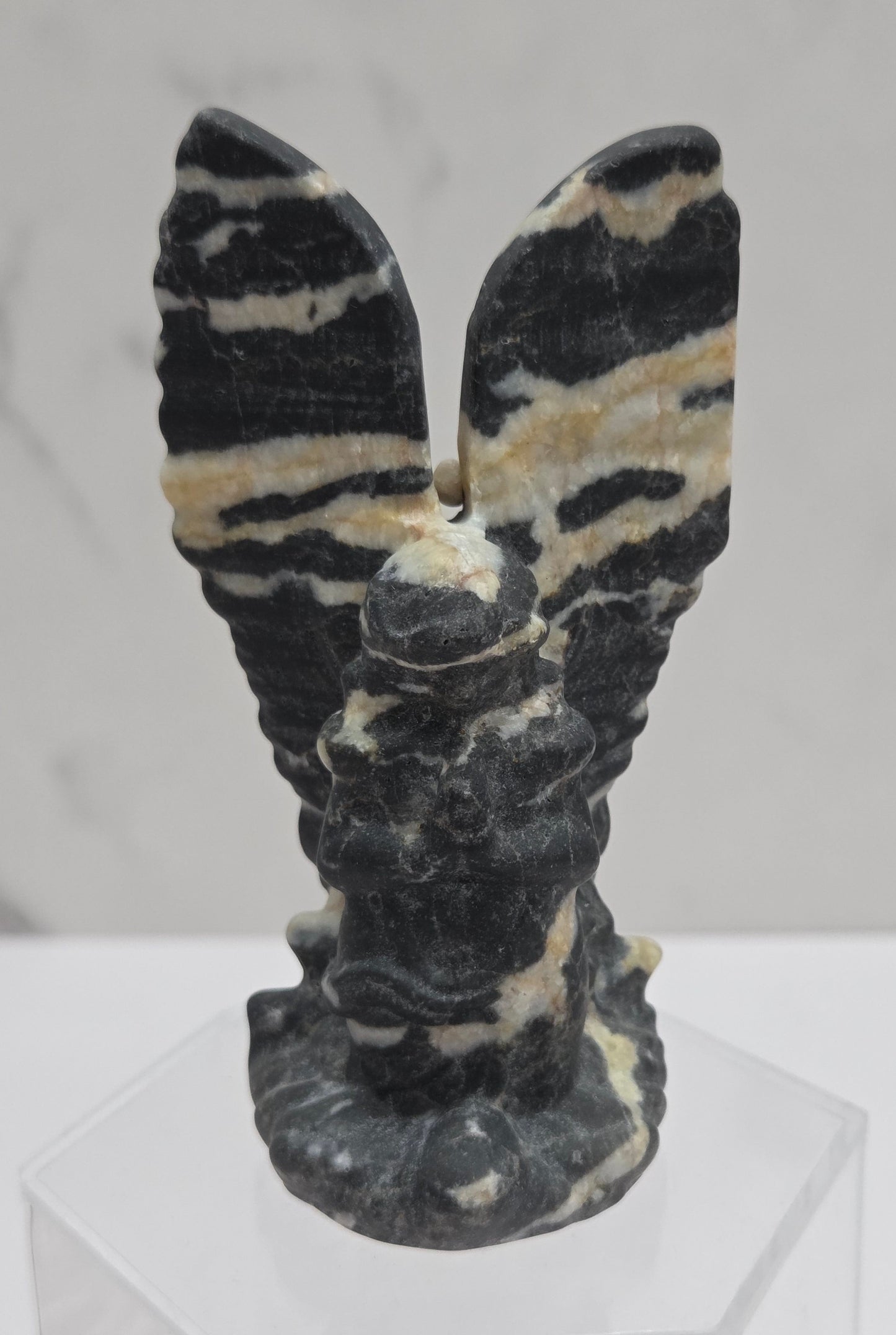 Zebra Jasper praying angel carving on an acrylic stand on a white background