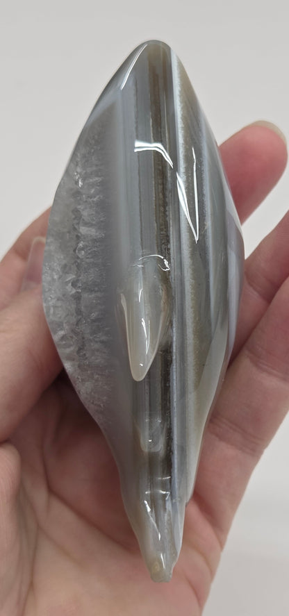 Agate shark carving with banding on a white background