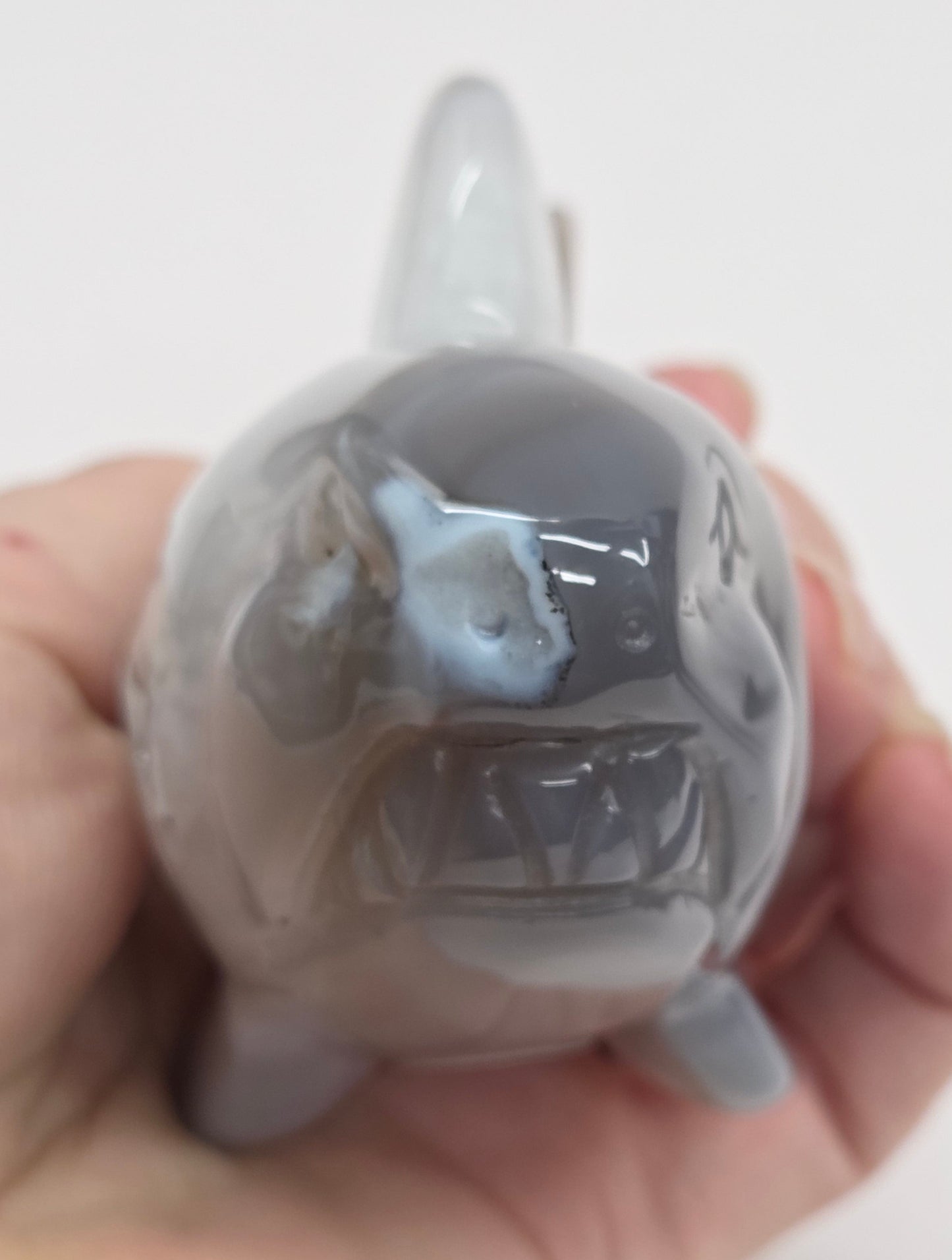 Agate shark carving with banding on a white background