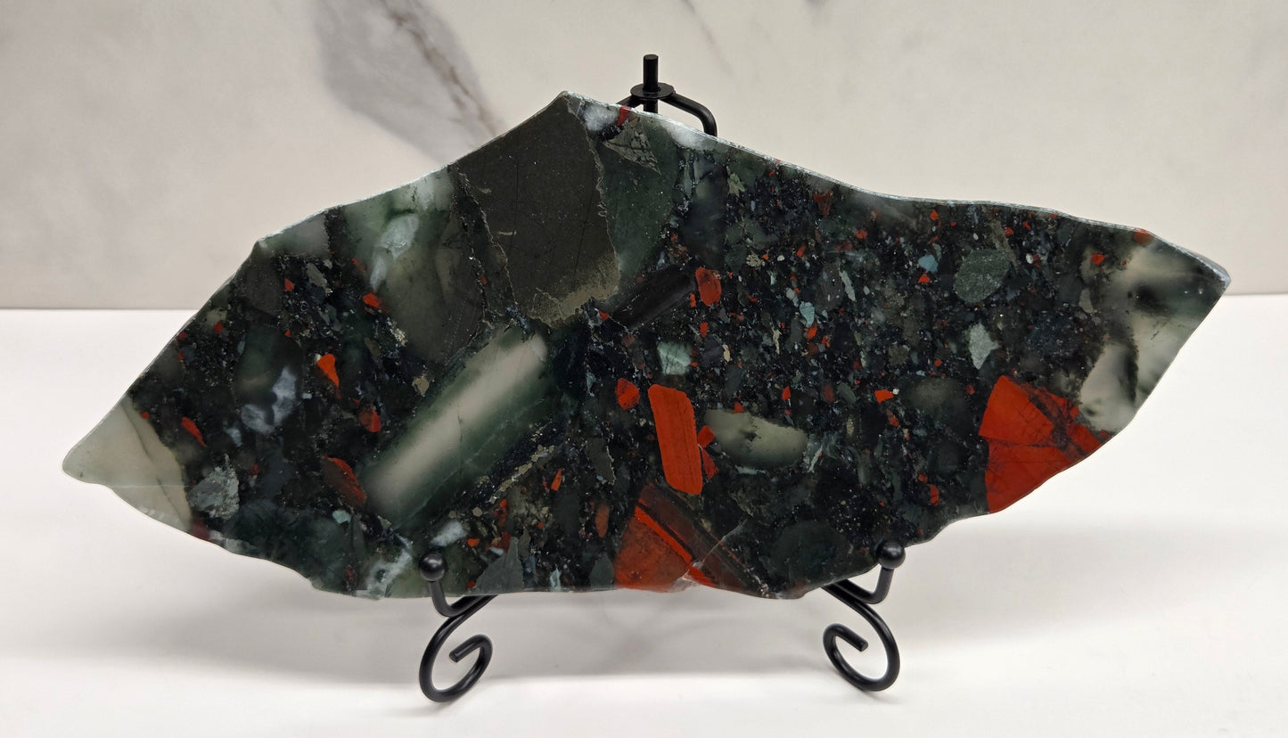 Dark stone African Bloodstone slab with red and gray patterns on a white surface.