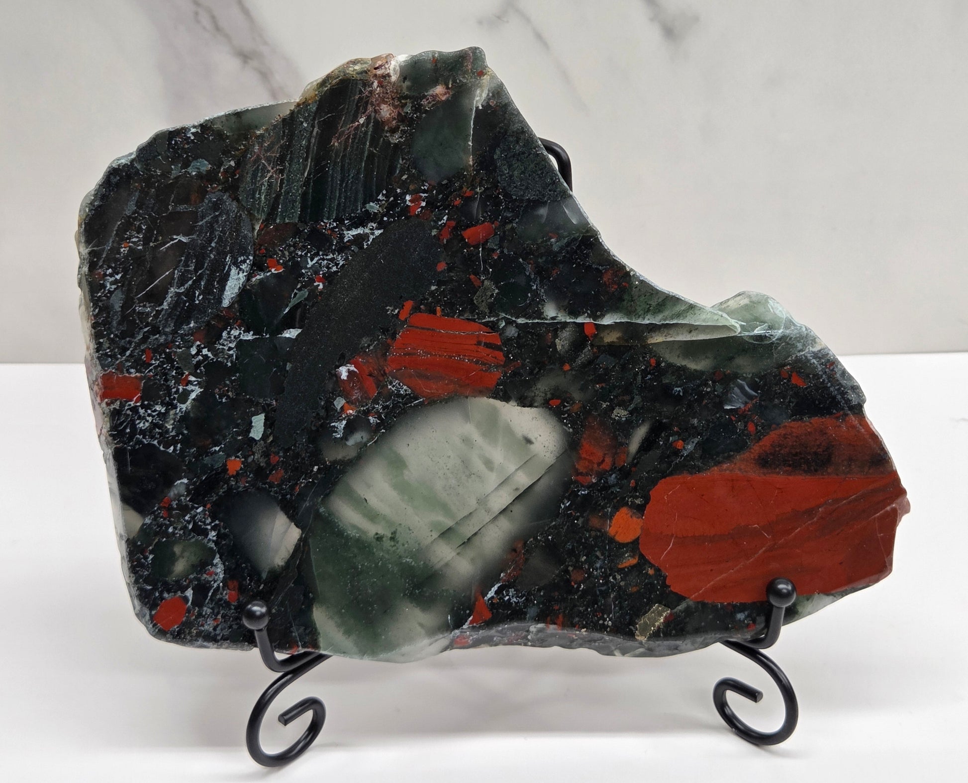 Dark stone African Bloodstone slab with red and gray patterns on a white surface.