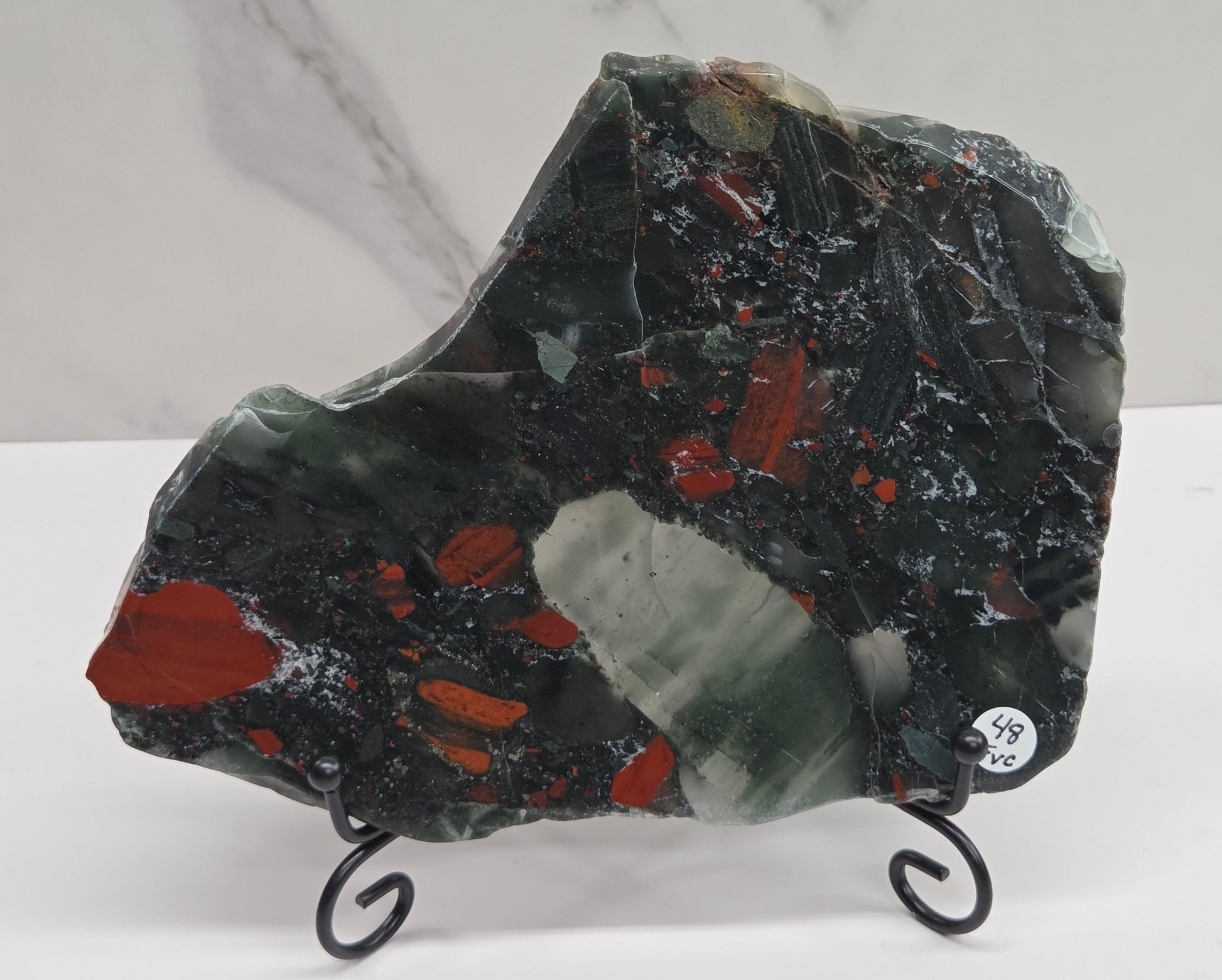 Dark stone African Bloodstone slab with red and gray patterns on a white surface.