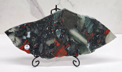 Dark stone African Bloodstone slab with red and gray patterns on a white surface.