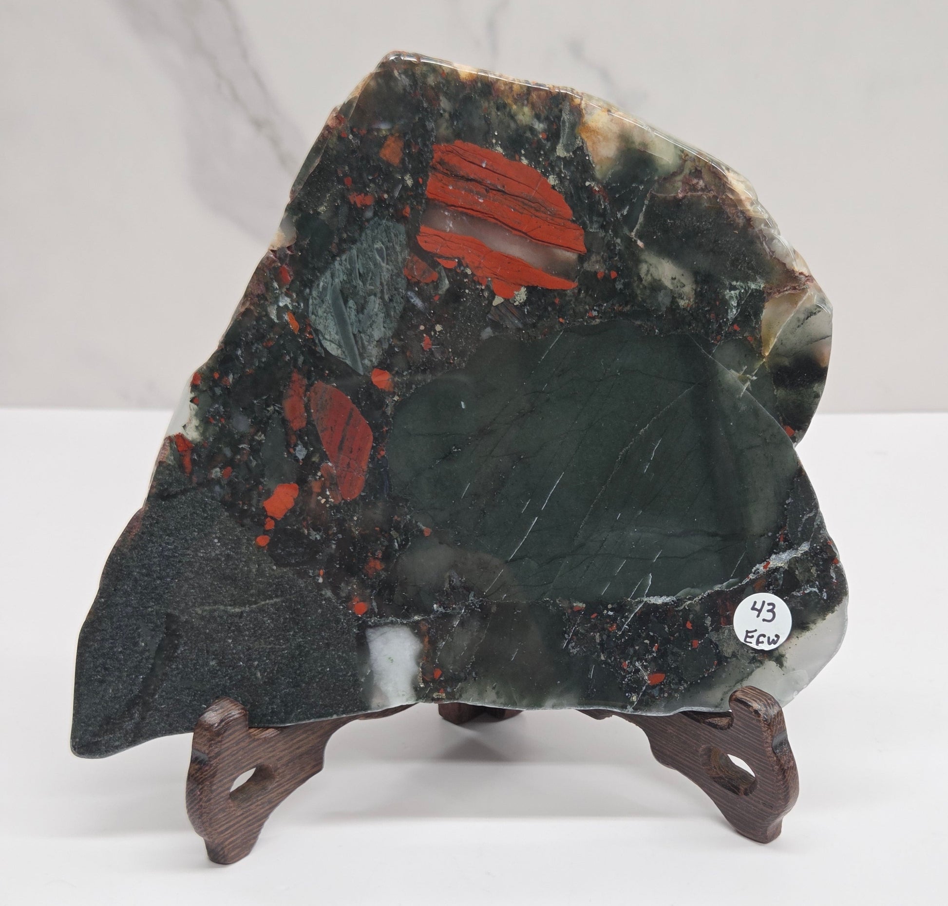 Dark stone African Bloodstone slab with red and gray patterns on a white surface.