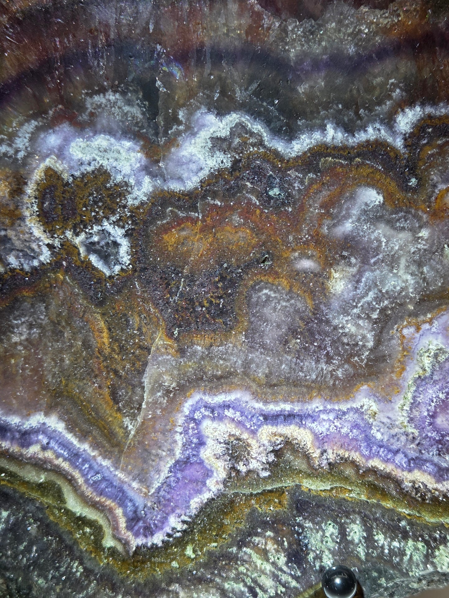 Close-up of a multicolored stone with purple, brown, and gray patterns