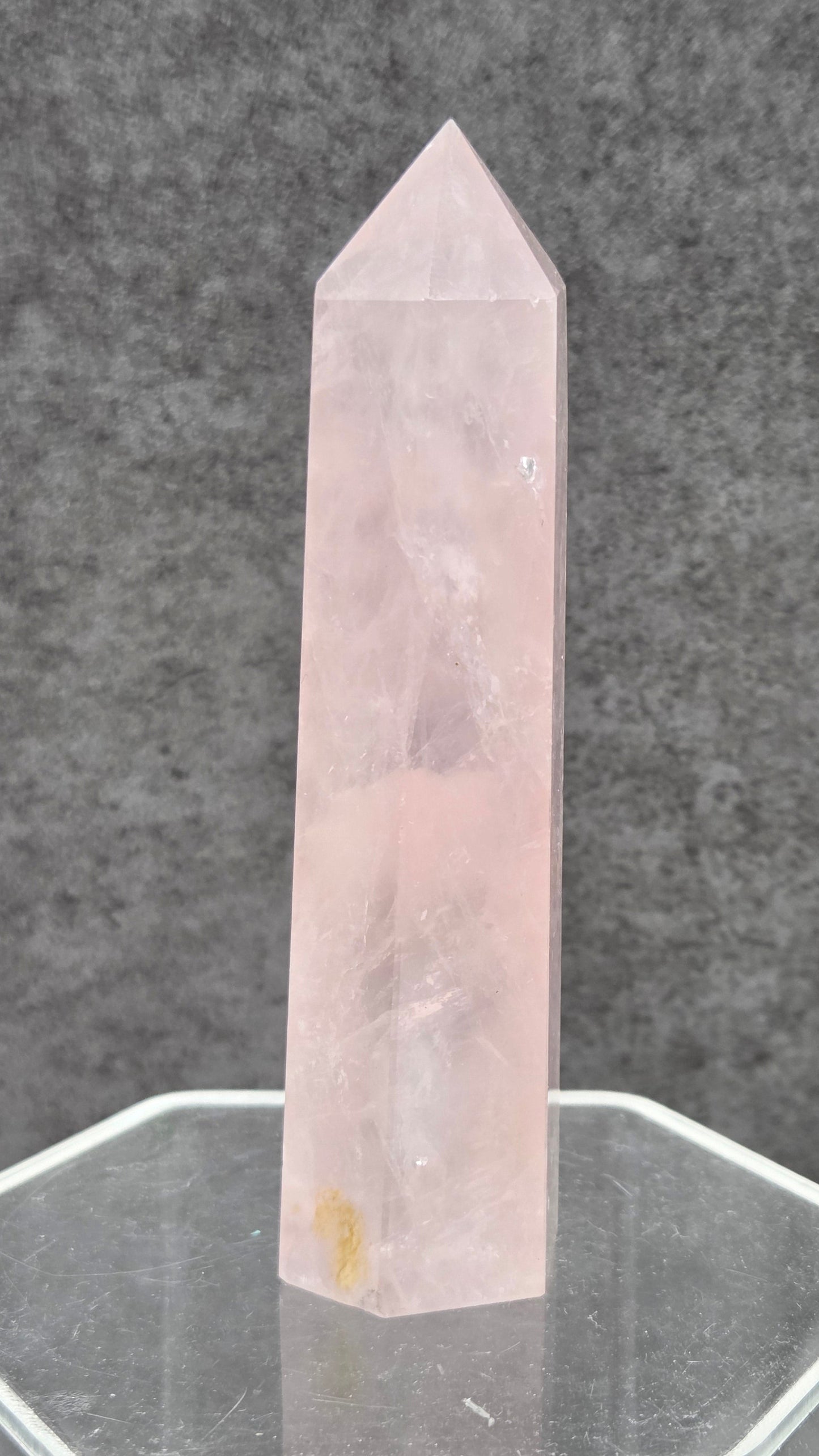 rose quartz crystal point with a gray background
