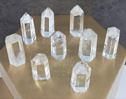 Clear crystal towers on a gold stand with a dark background