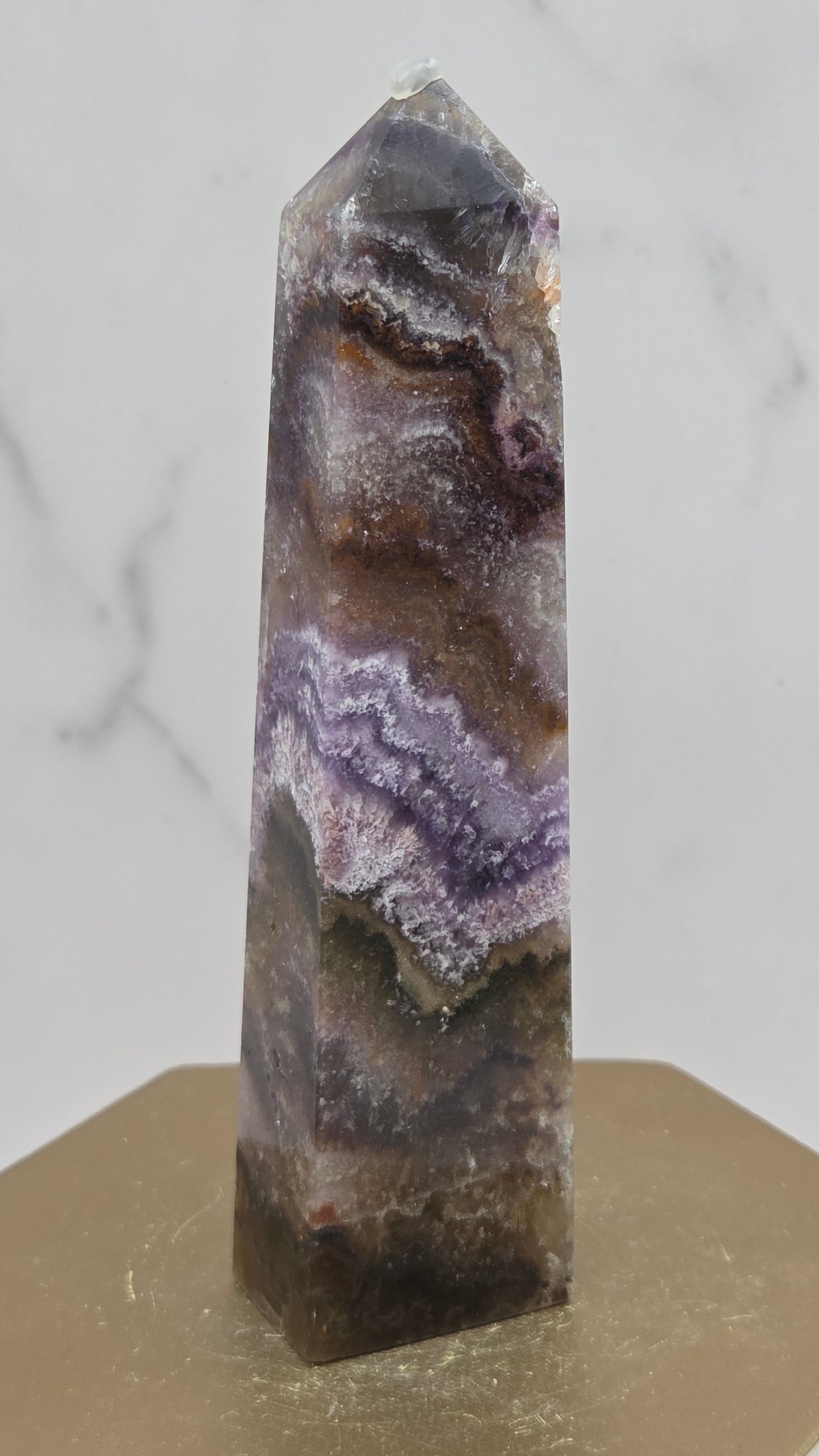 Crystal with purple and brown patterns on a light gray background