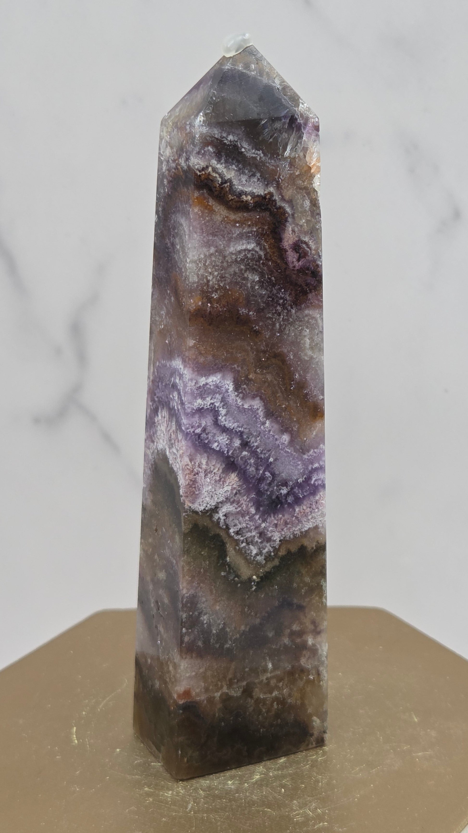Crystal with purple and brown patterns on a light gray background