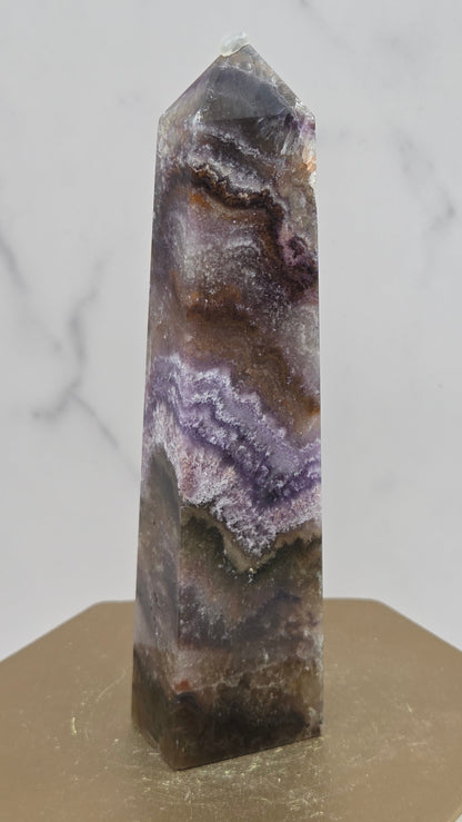 Crystal with purple and brown patterns on a light gray background